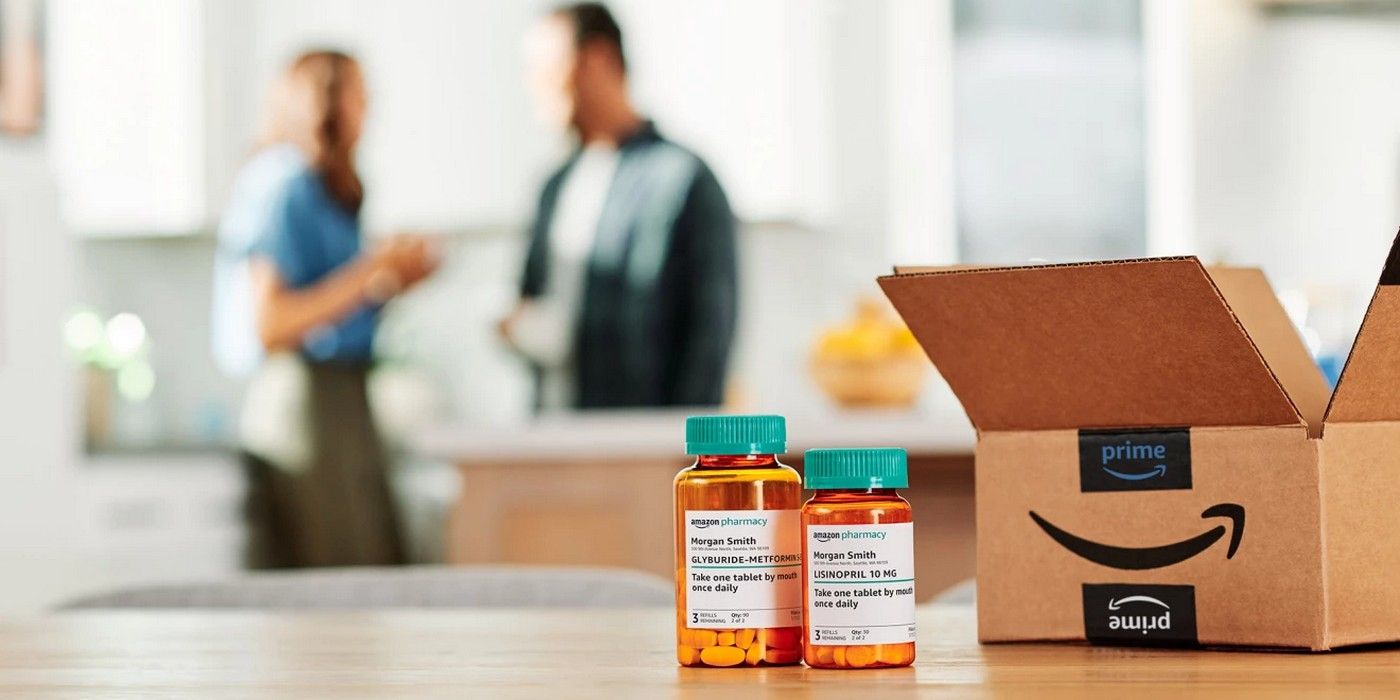 Two medicine bottles next to an open Amazon cardboard box in the foreground, with a man and a woman in the background