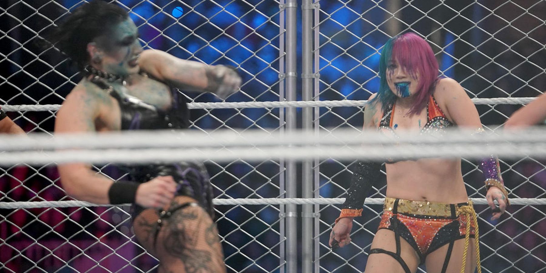 Asuka grins after hitting Rhea Ripley in the face with green mist during the women's WarGames match at WWE Survivor Series in 2022.