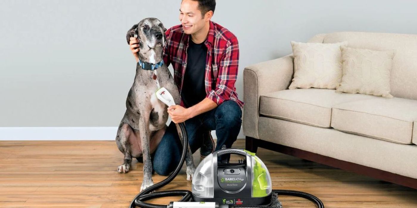 A man cleans his dog with a Bissell Barkbath