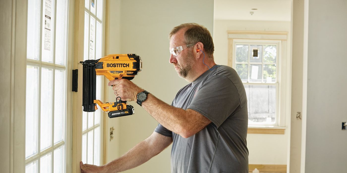 A man uses a Bostitch Brad Nailer on his door