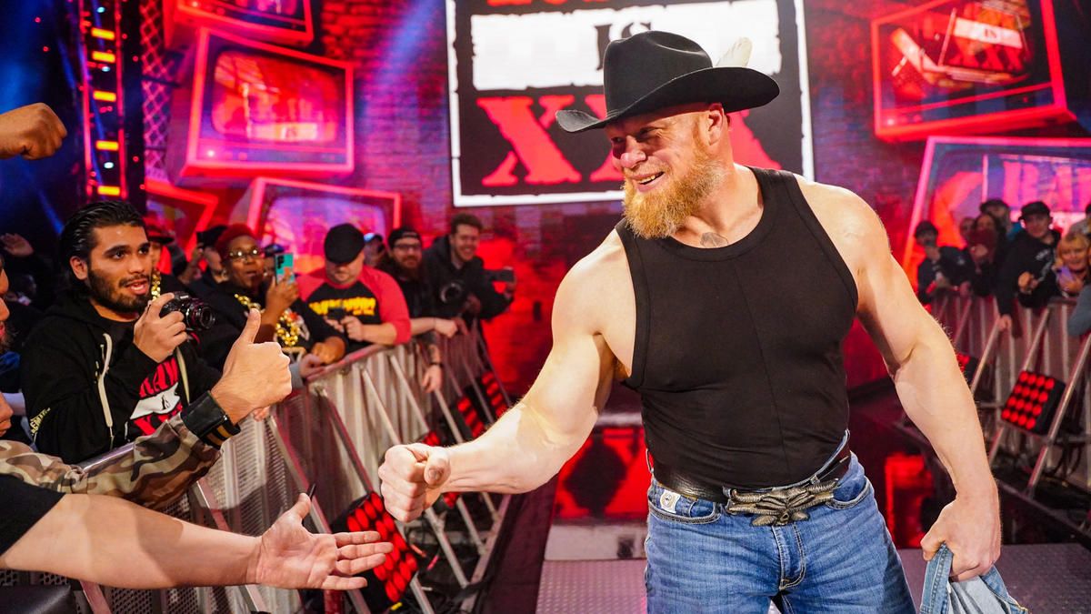 Brock Lesnar fist bumps a fan after helping Theory defeat Bobby Lashley at WWE's Raw is 30 show.