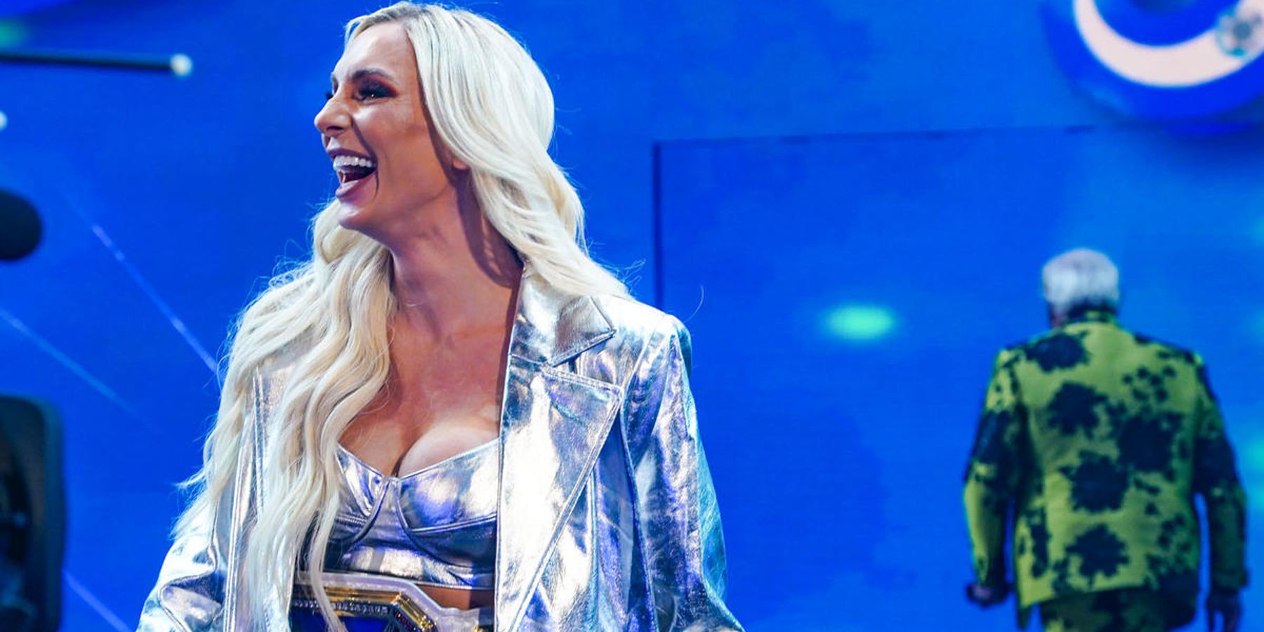 Charlotte Flair makes her way to the ring during WWE's Raw is 30 episode. Her father, Ric Flair, is leaving in the background.