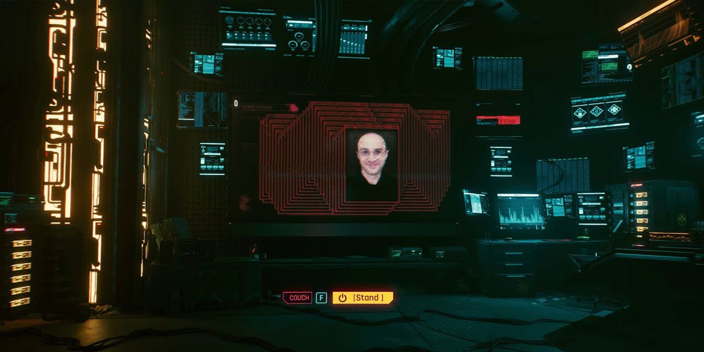 Cyberpunk 2077's Dev Room que contém uma enorme TV que mostra fotos dos desenvolvedores do Cyberpunk 2077.  Há também a opção de ficar de pé no sofá.