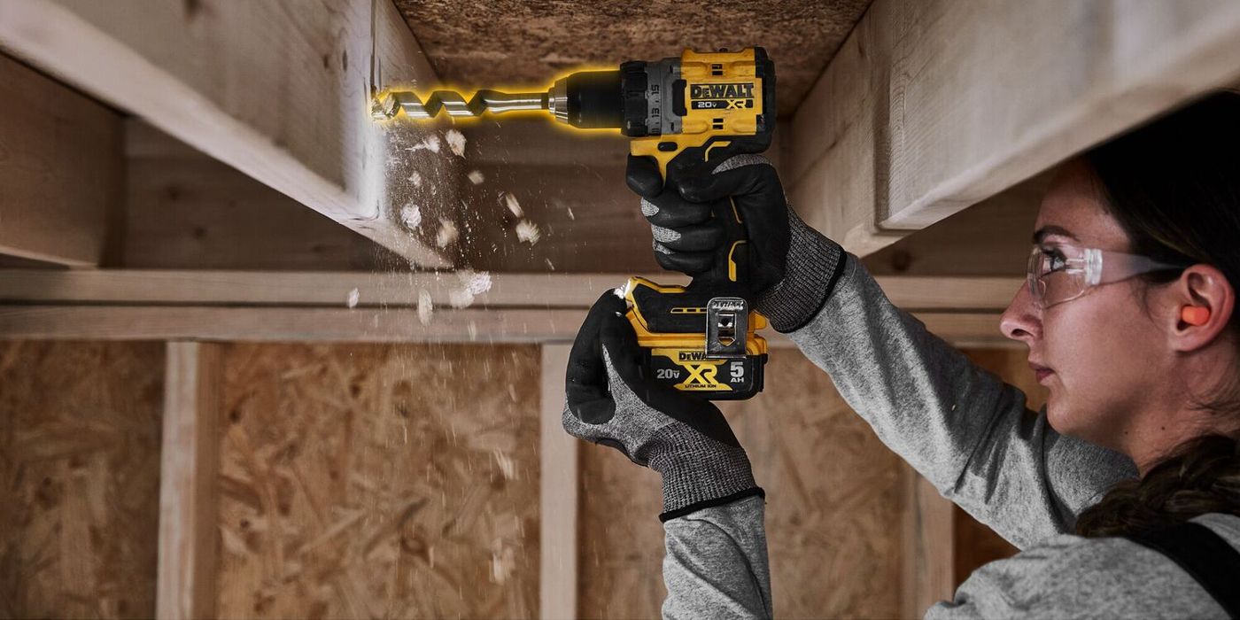 Uma mulher usa uma furadeira elétrica DeWalt