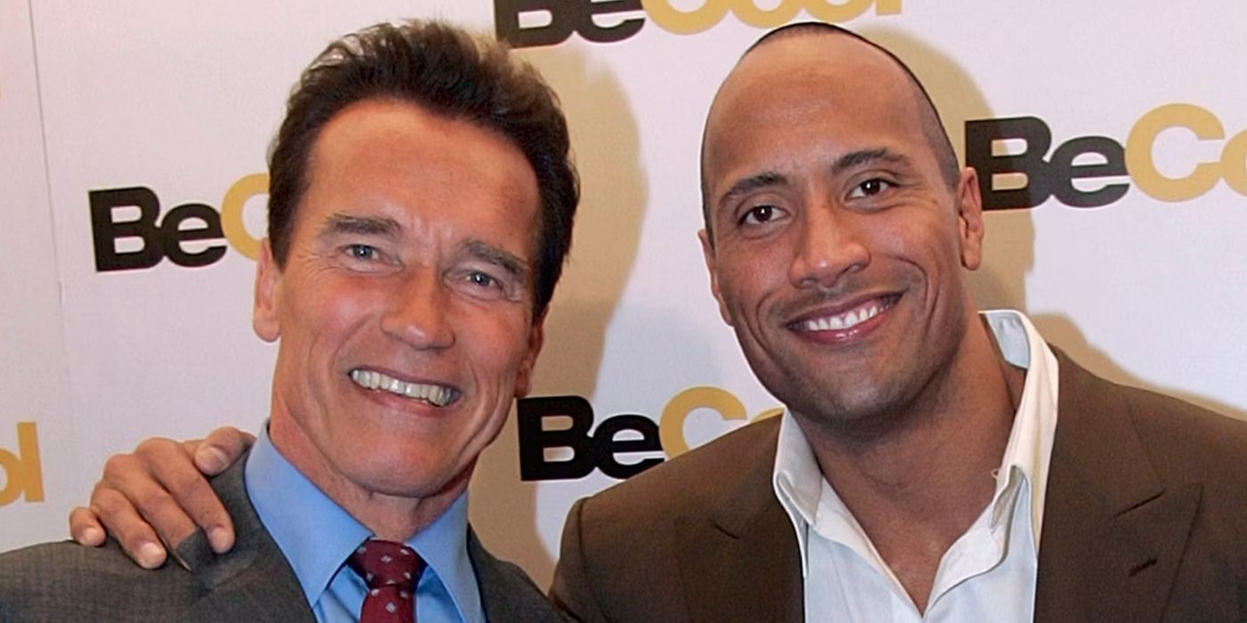 Dwayne Johnson posing with Arnold Schwarzenegger