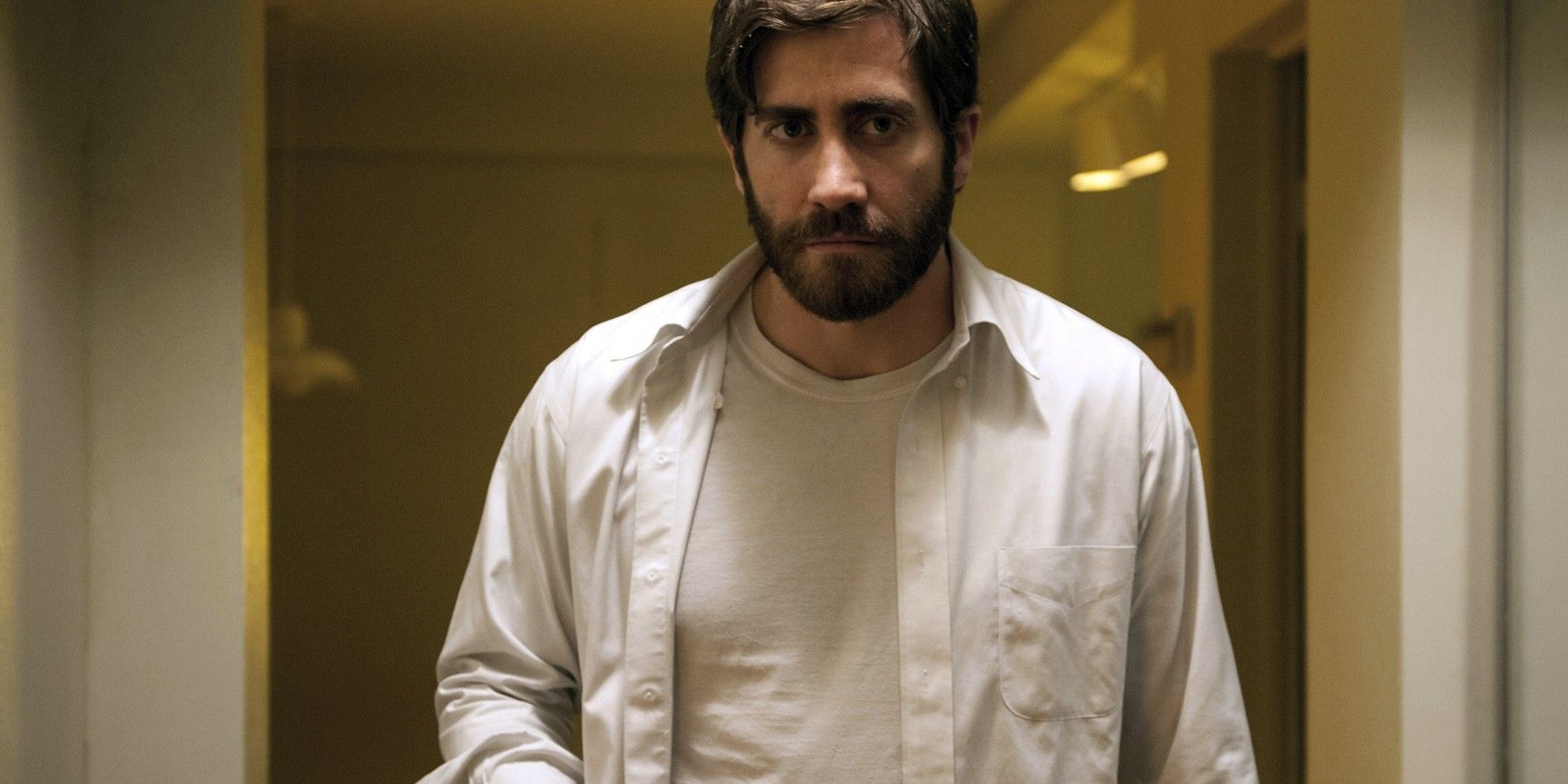 Jake Gyllenhaal walking down a hallway in Enemy