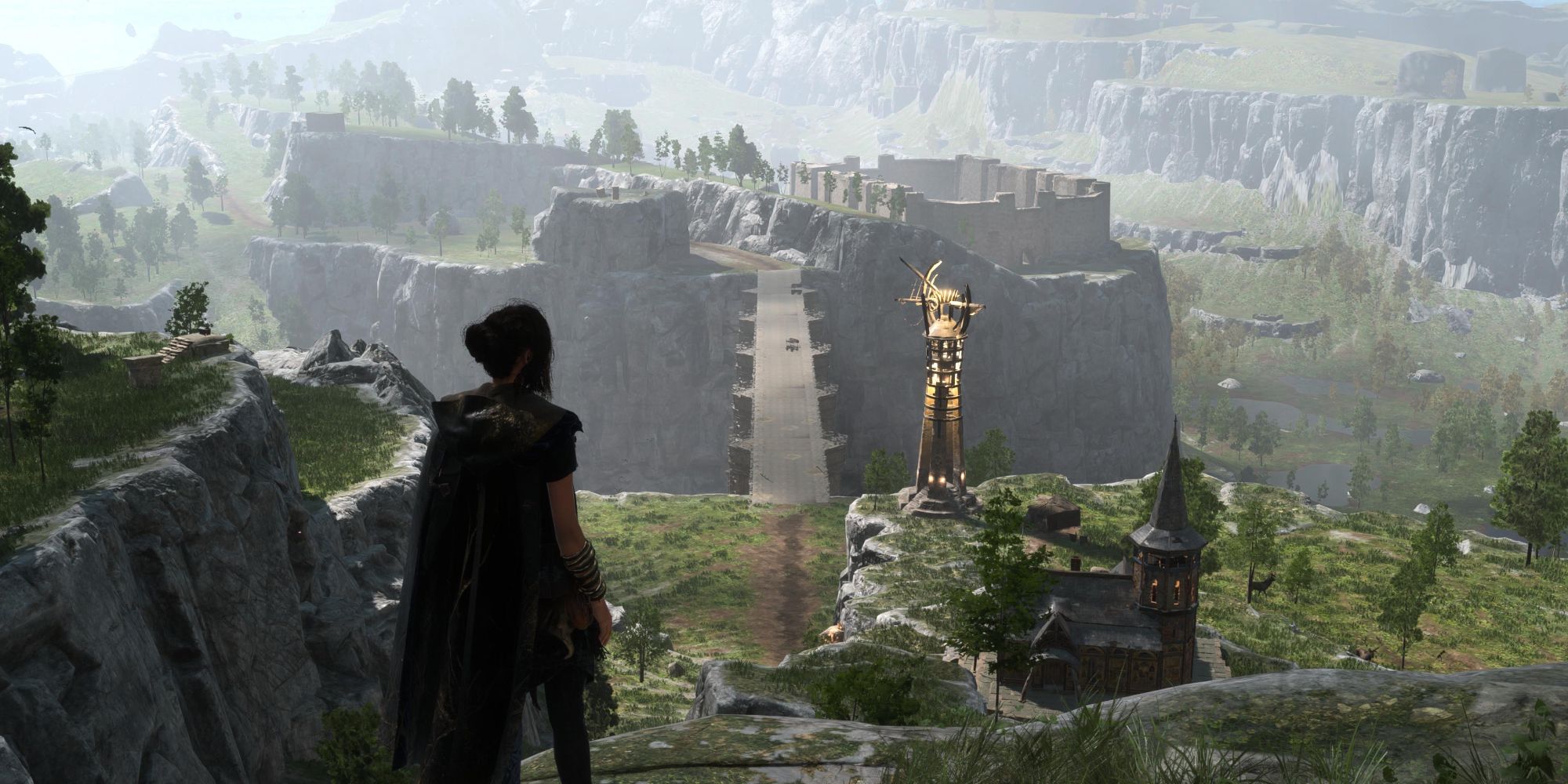 Frey Holland in Forspoken standing on the edge of a cliff looking at the landscape below. Ahead of and below her is a building with a spired tower, a golden Belfry, and a large stone bridge spanning a gorge.