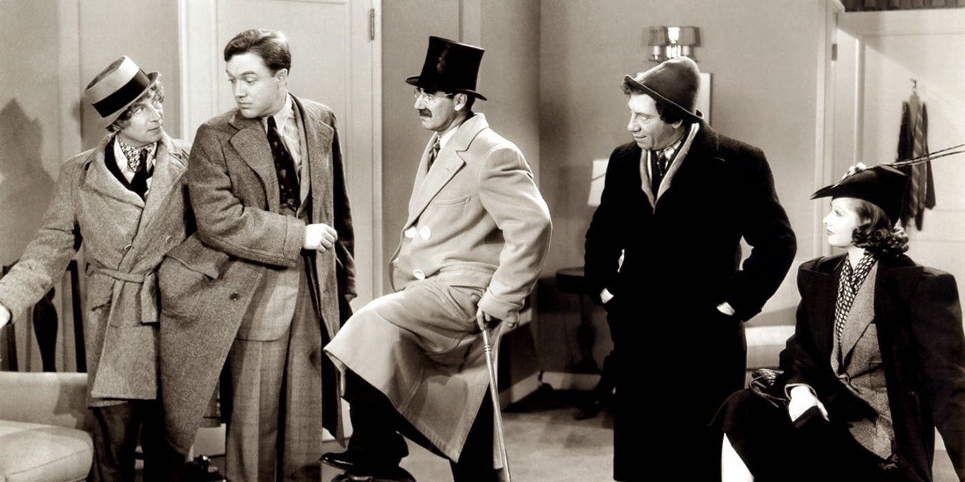 groucho chico and zippo marx surrounding a confused man with a woman sitting in room service