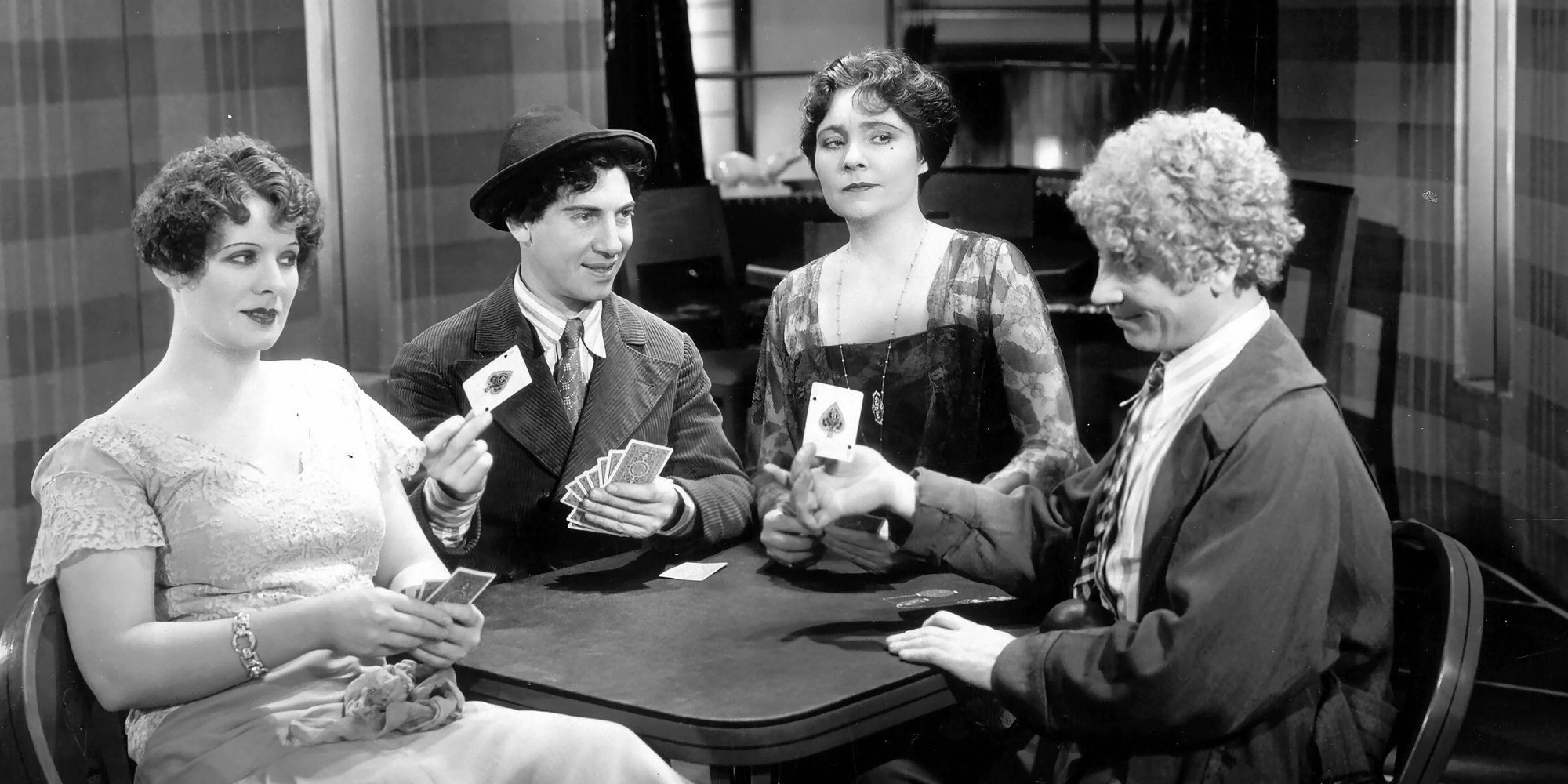 harpo and chico marx and margaret dumont and another woman playing a card game in animal crackers