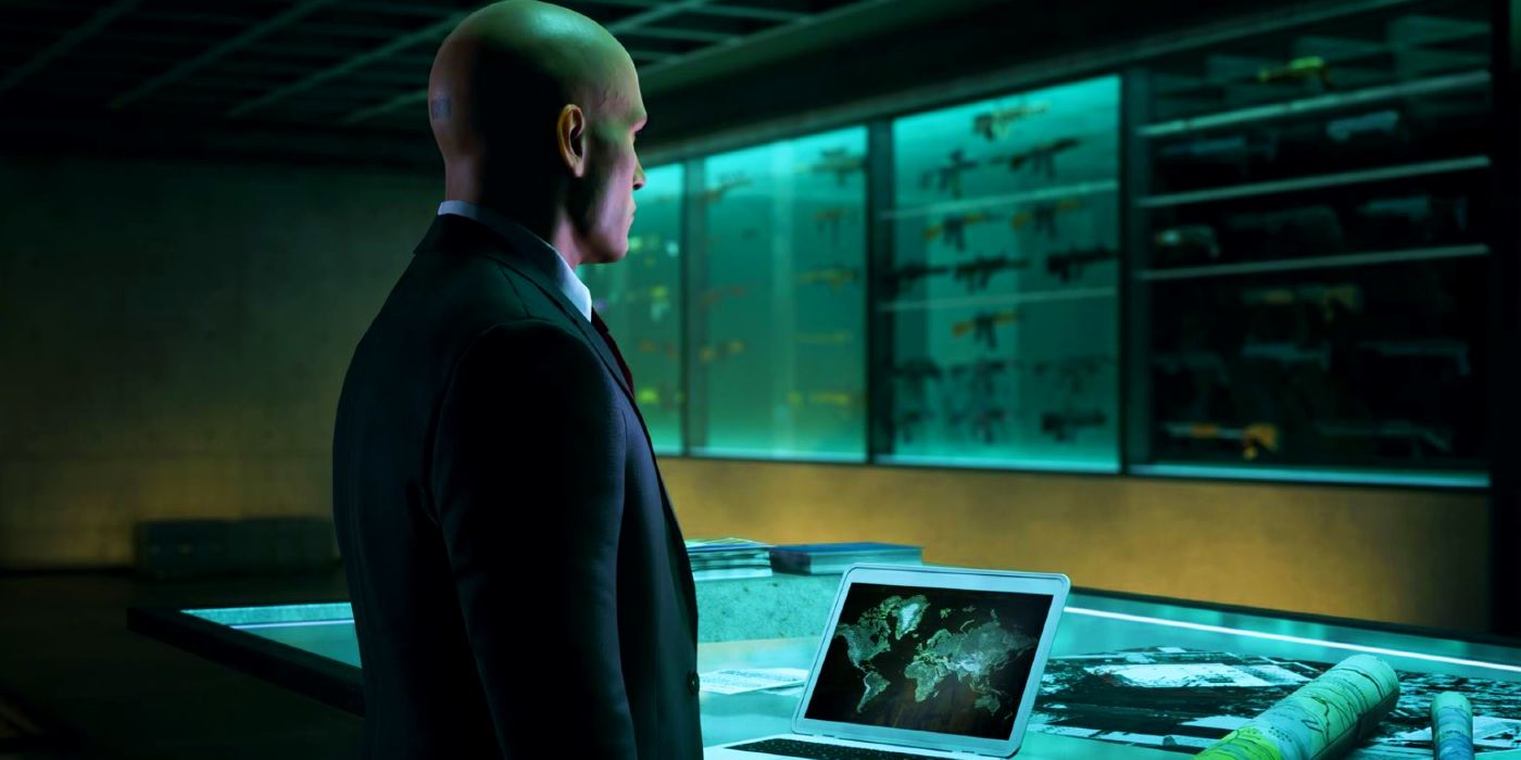 Agent 47 standing in front of his laptop inside his hideout in Hitman: Freelancer