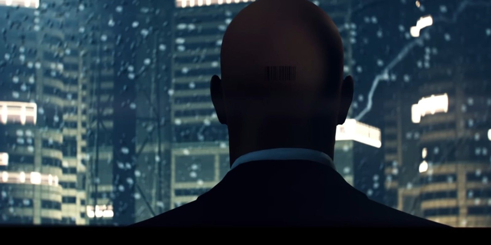 Hitman: Freelancer's Agent 47 looks out on a rainy cityscape.
