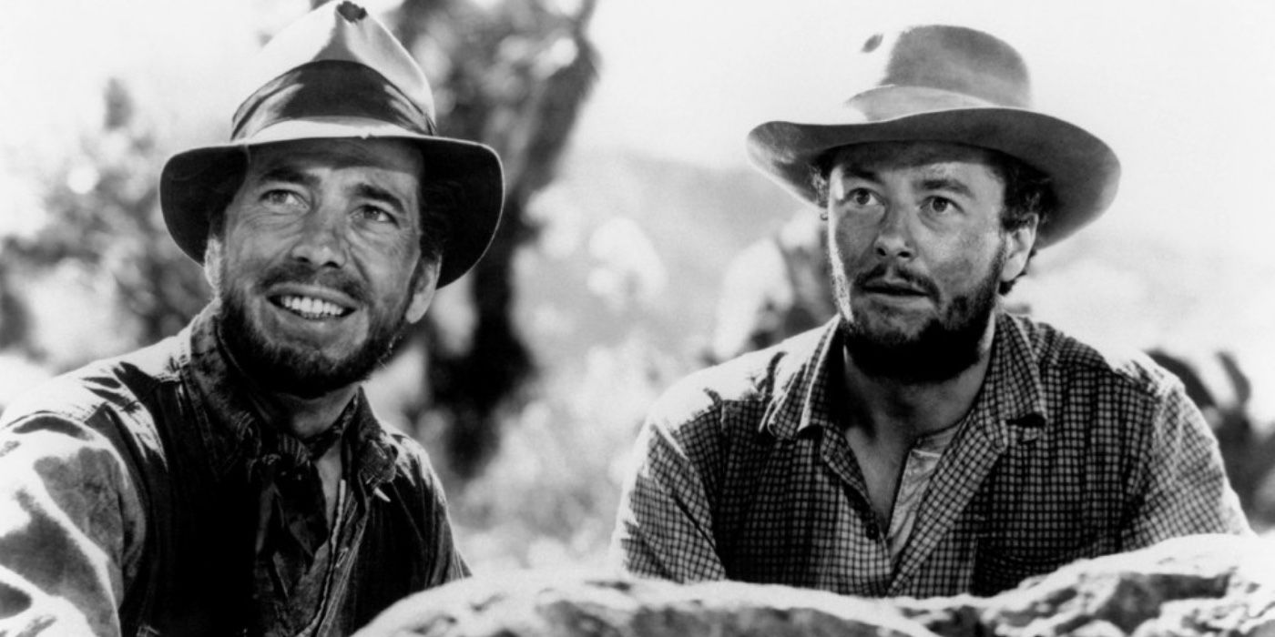 Humphrey Bogart como Fred C. Dobbs y Tim Holt como Bob Curtin sonriendo en El tesoro de la Sierra Madre
