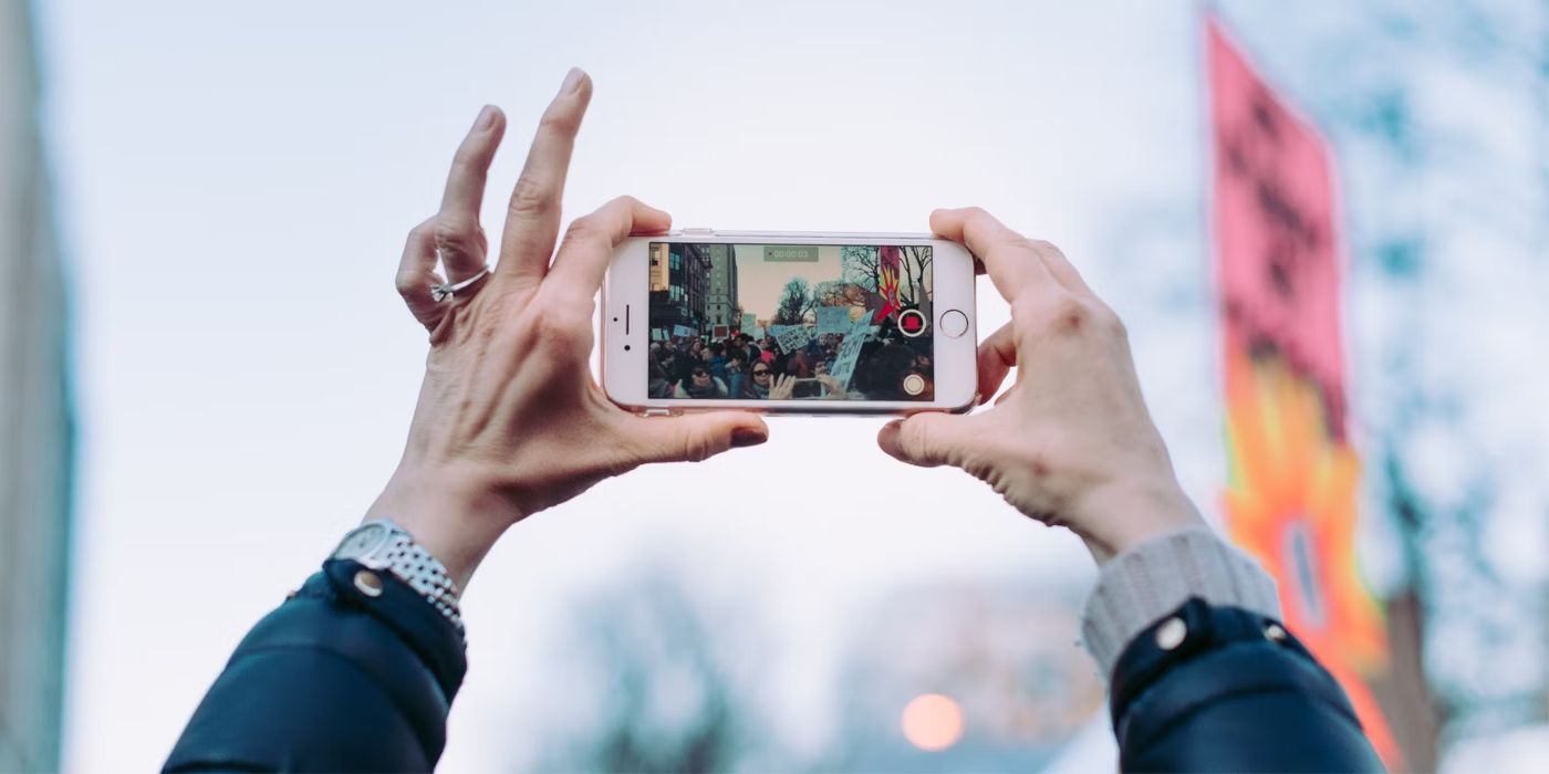 As mãos tiram fotos em um iPhone usando o modo de vídeo