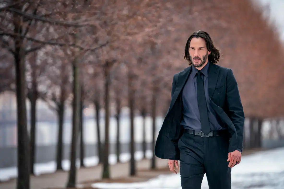 Keanu Reeves walking along snowy ground in John Wick: Chapter 4.