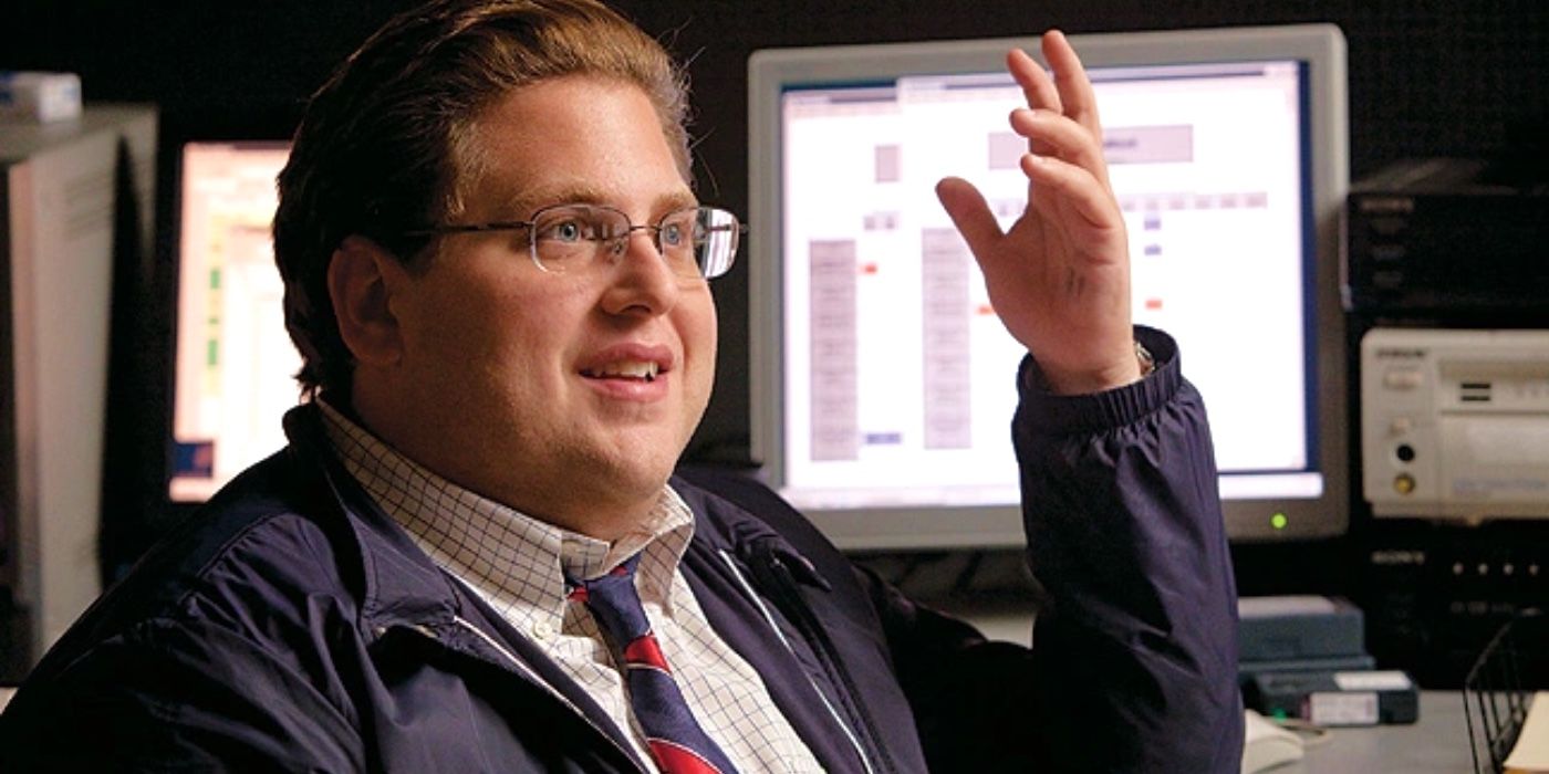 Jonah Hill as Peter Brand smiling and raising his hand in Moneyball