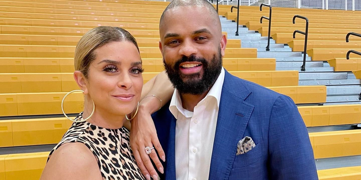 RHOP's Juan and Robyn Dixon smiling together in front of bleachers
