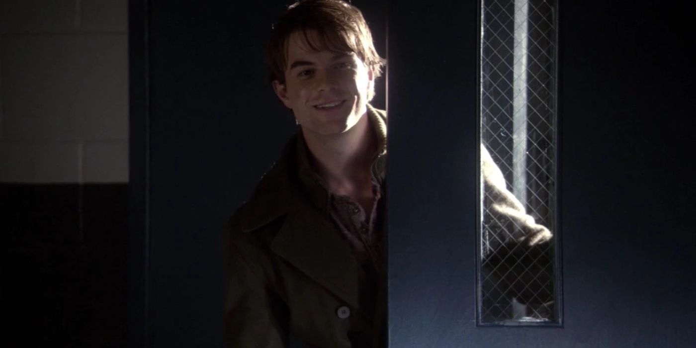 Kol smiling and standing by a door in The Vampire Diaries