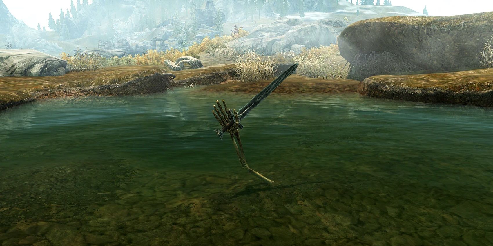A skeletal hand holds a sword out of a lake in Skyrim.