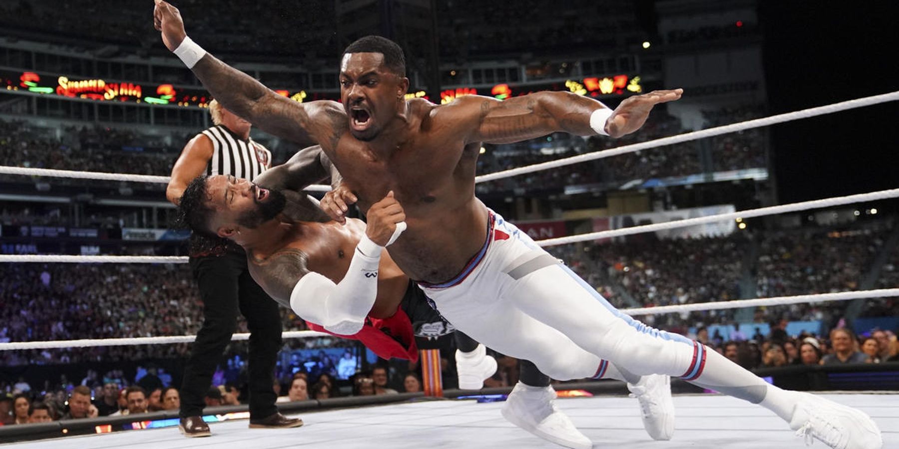 Montez Ford delivers a monster clothesline during a match against The Usos at WWE SummerSlam.