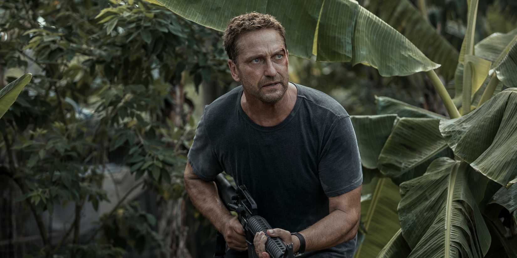 Gerard Butler holds a gun in Plane