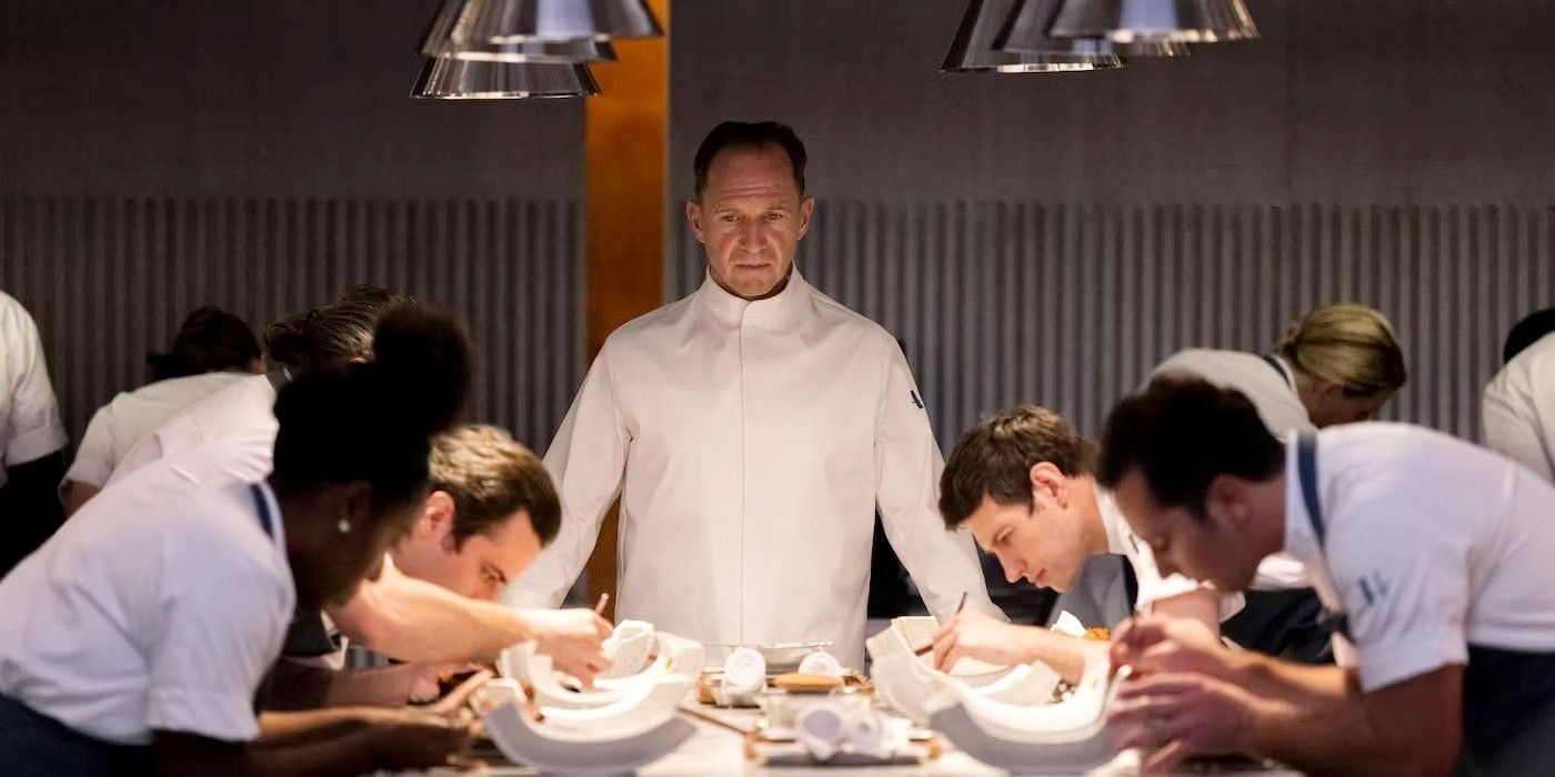 Ralph Fiennes como Chef Slowik olhando para seus outros chefs em O Menu