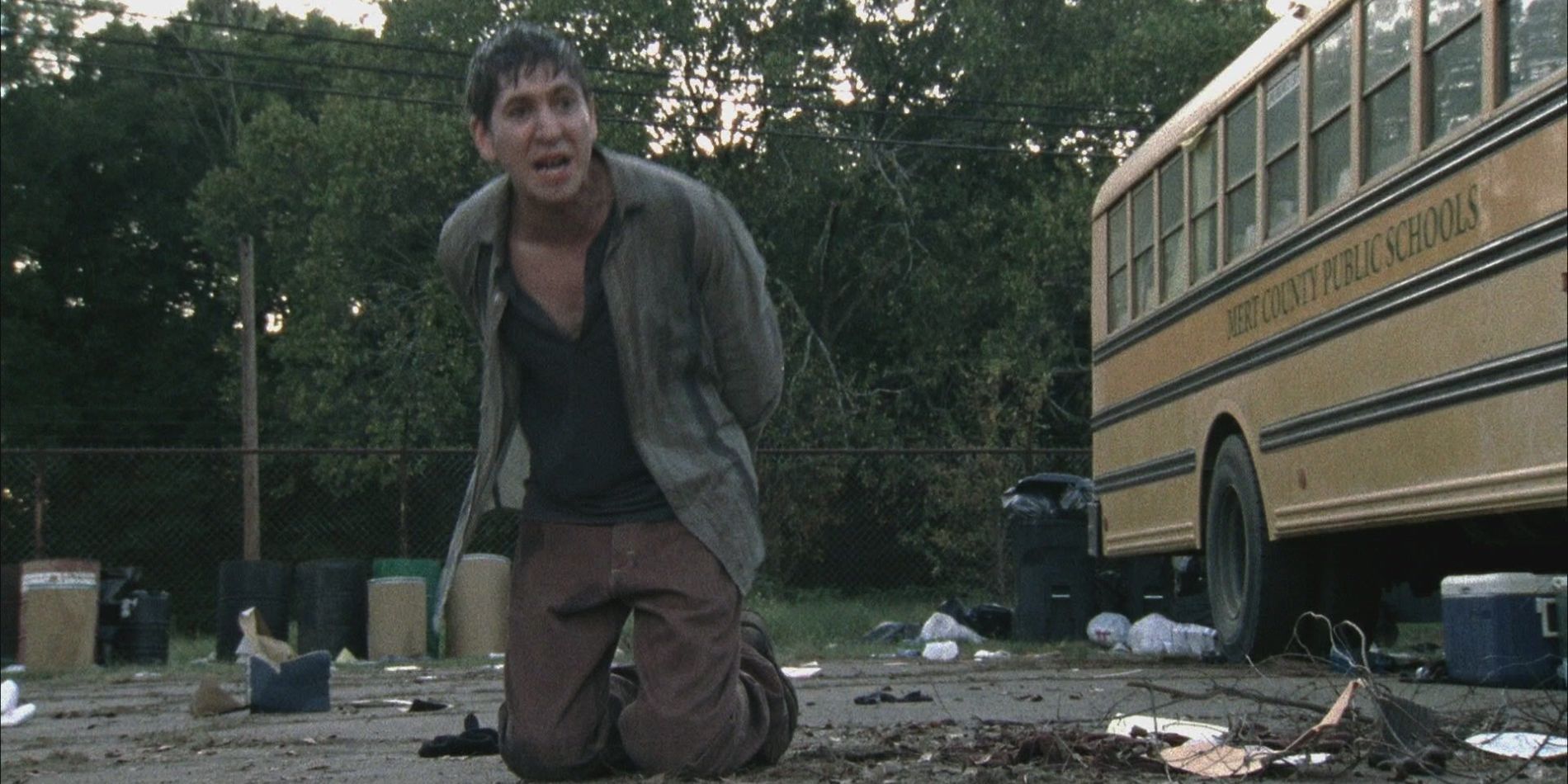 Randall Culver ajoelhado no chão perto de um ônibus em The Walking Dead.