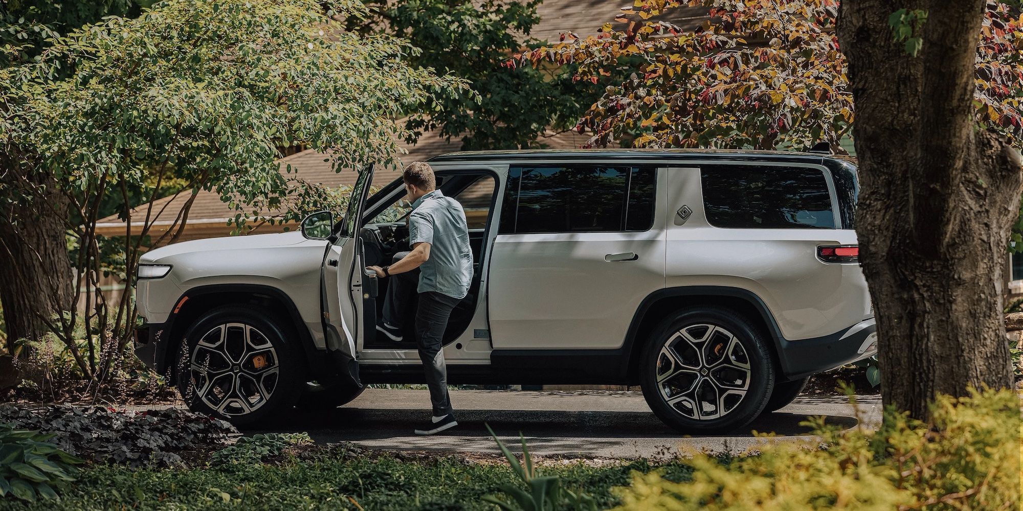 A Rivian driver entering the R1T using Roomy Entry and Exit