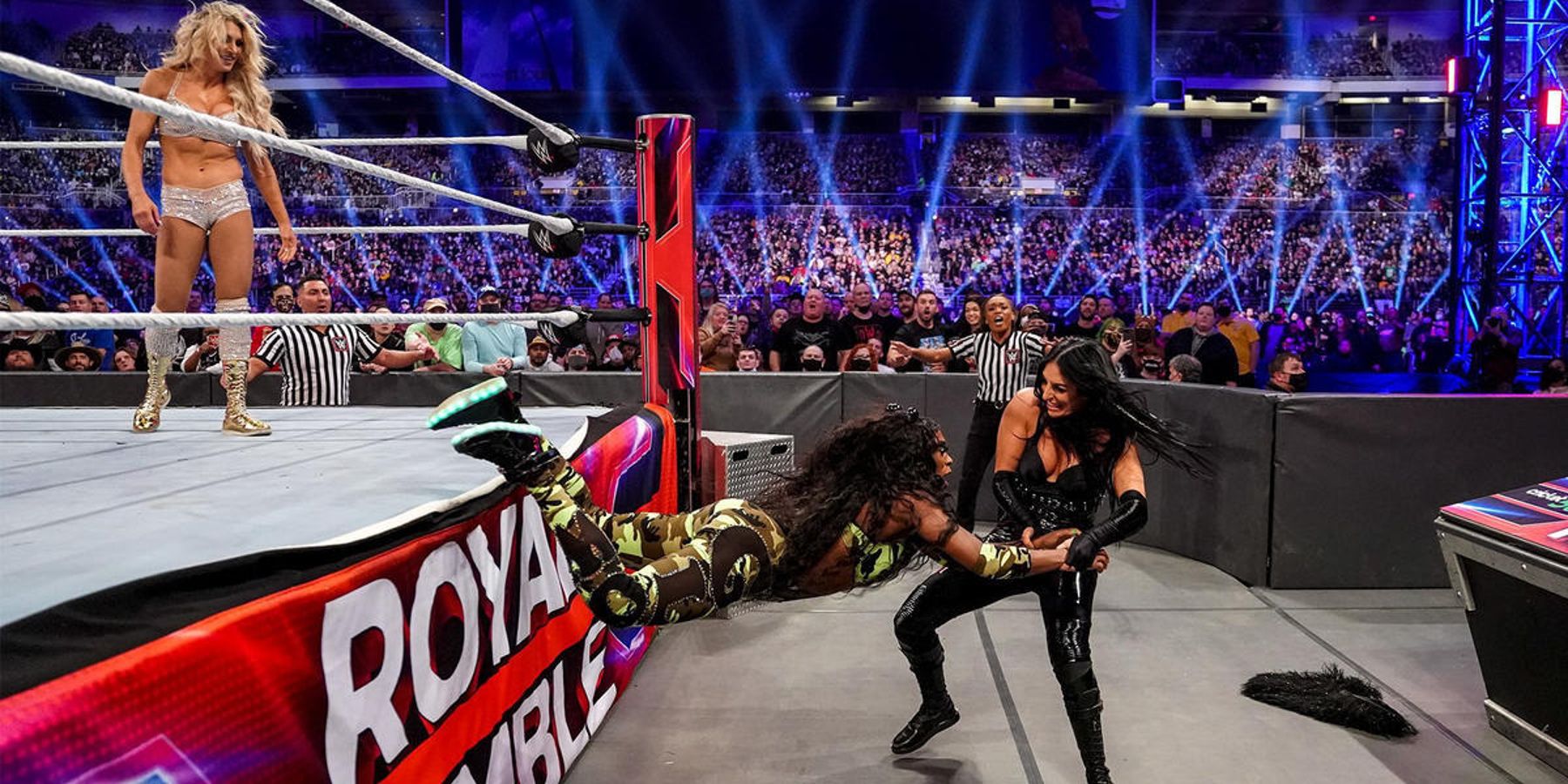 Charlotte Flair sourit alors que Sonya Deville sort Naomi du ring lors du match WWE Royal Rumble 2022.