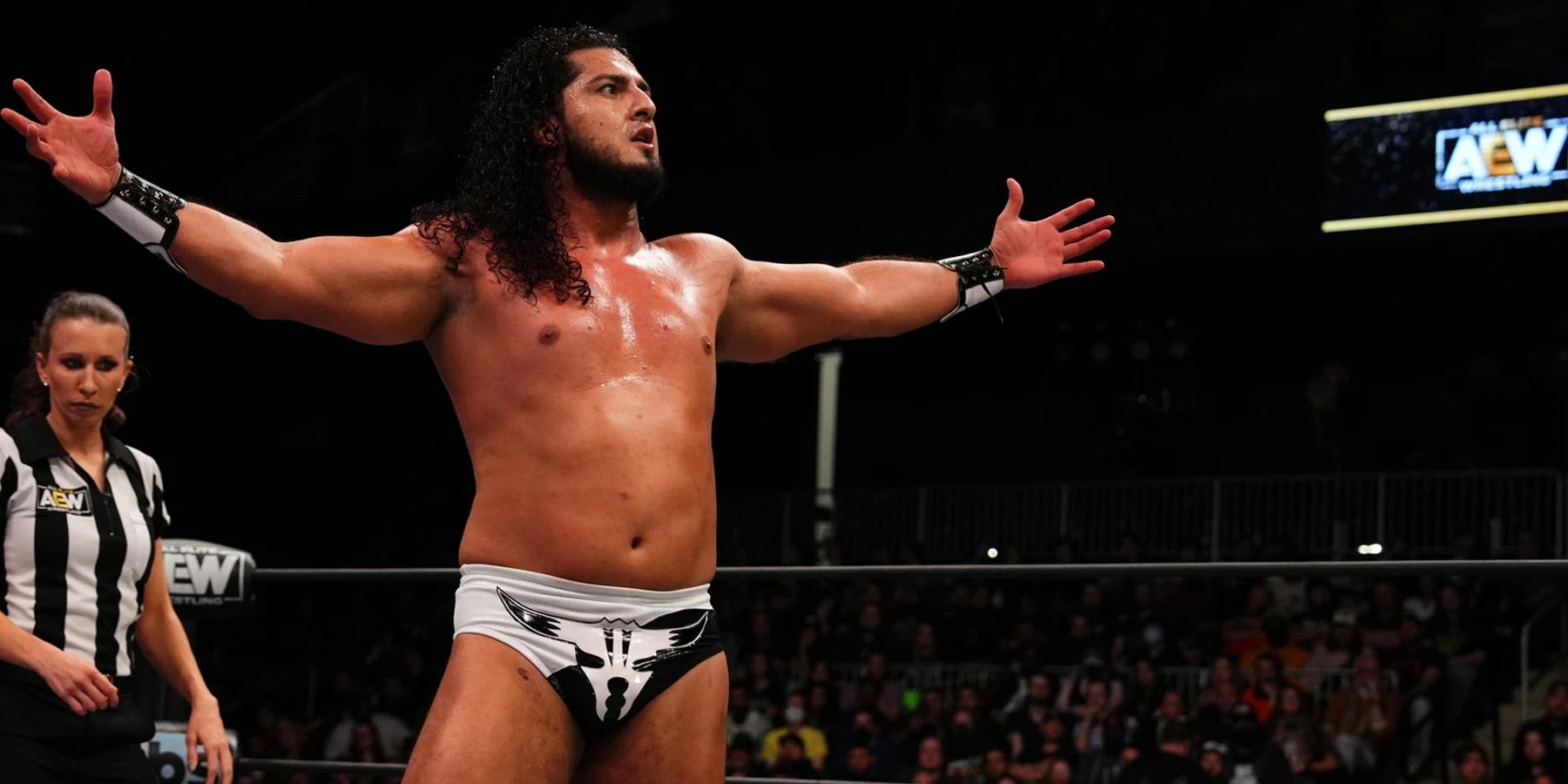 Rush plays to the crowd during a match against Hangman Adam Page for AEW in 2022.