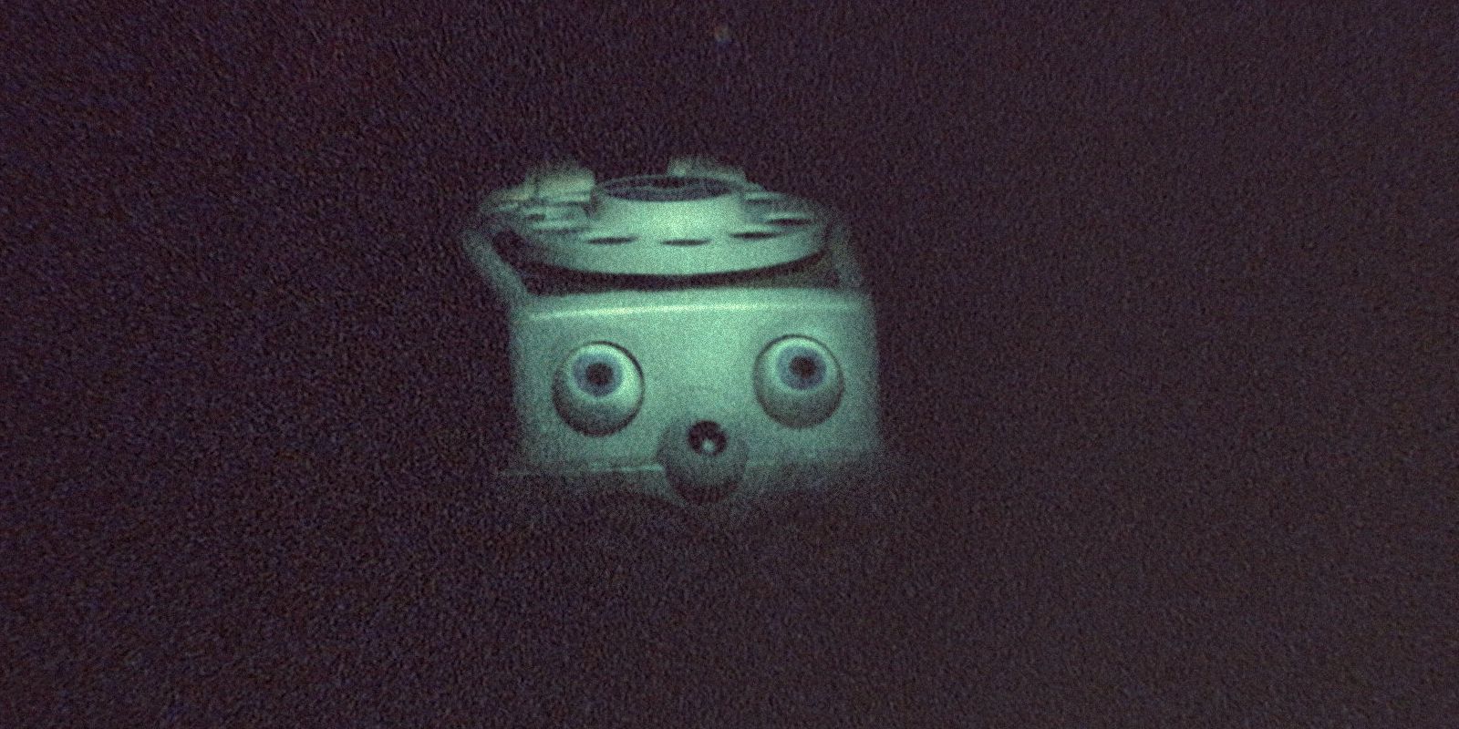 A creepy toy telephone peers out of the darkness in Skinamarink