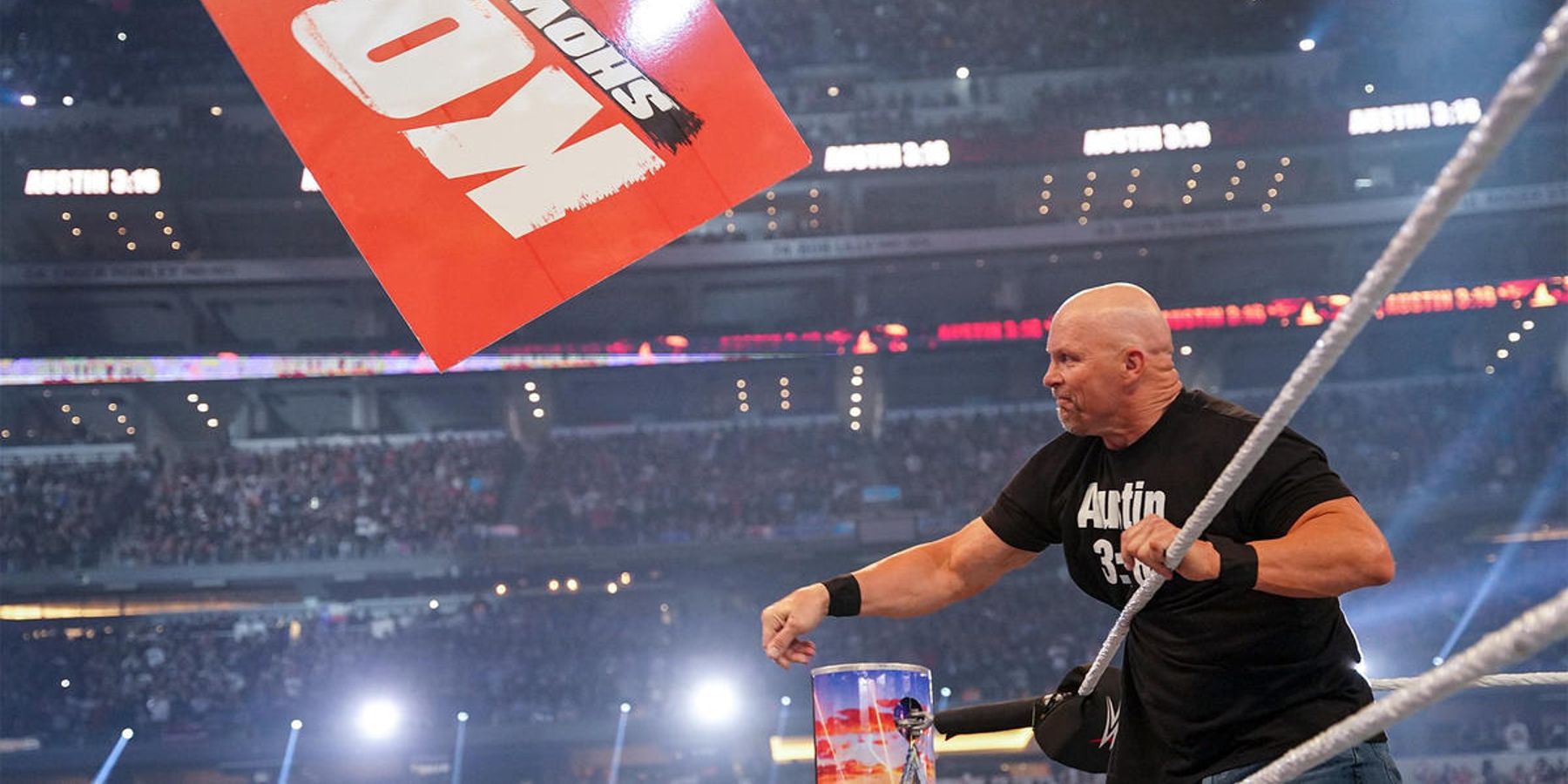 Stone Cold lance l'une des pancartes de Kevin Owens hors du ring avant leur match à WrestleMania 38.