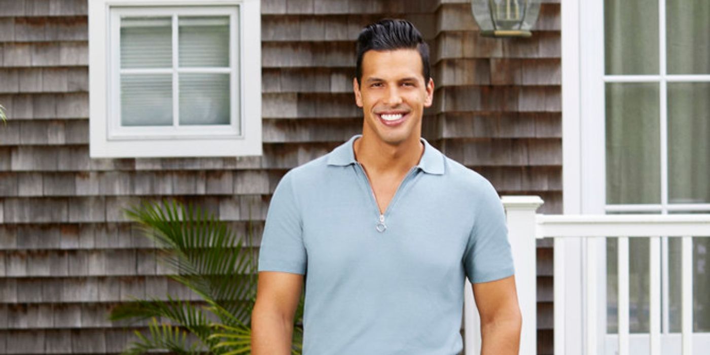 Chris Leoni from Summer House in a blue shirt smiling in front of a house
