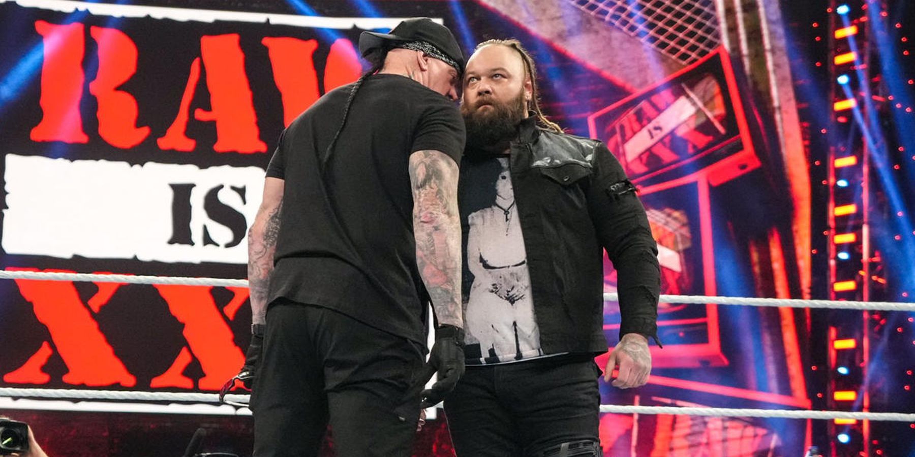 Undertaker whispers something to Bray Wyatt during WWE's Raw is 30 anniversary show in 2023.