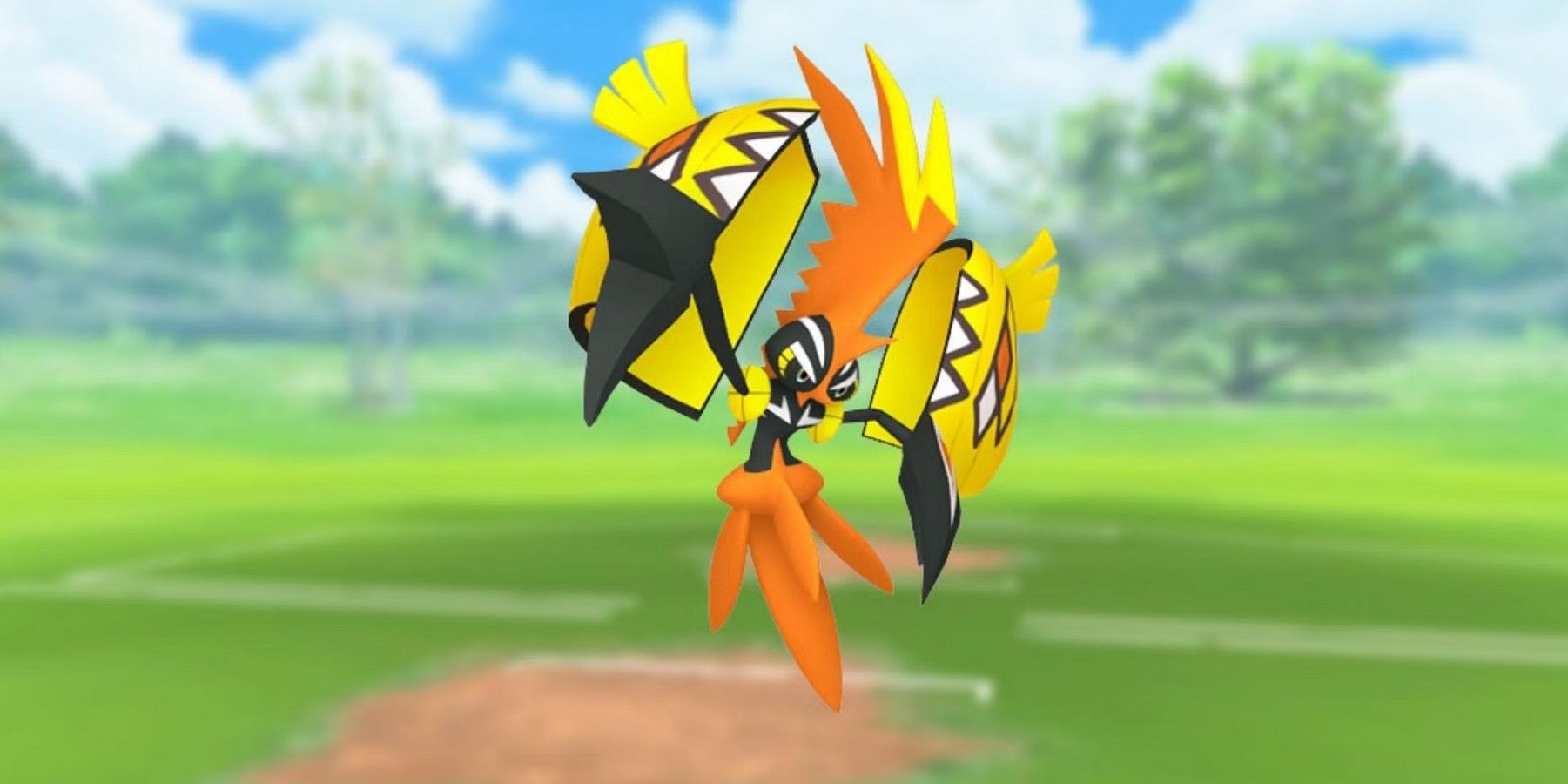Pokémon GO's Tapu Koko on a blurred baseball field background