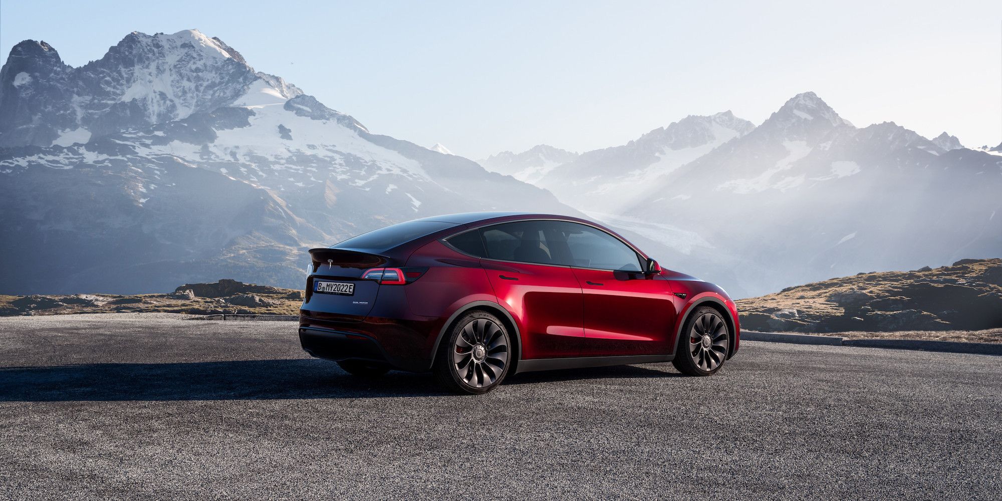 Um Tesla Model Y vermelho estacionado na estrada