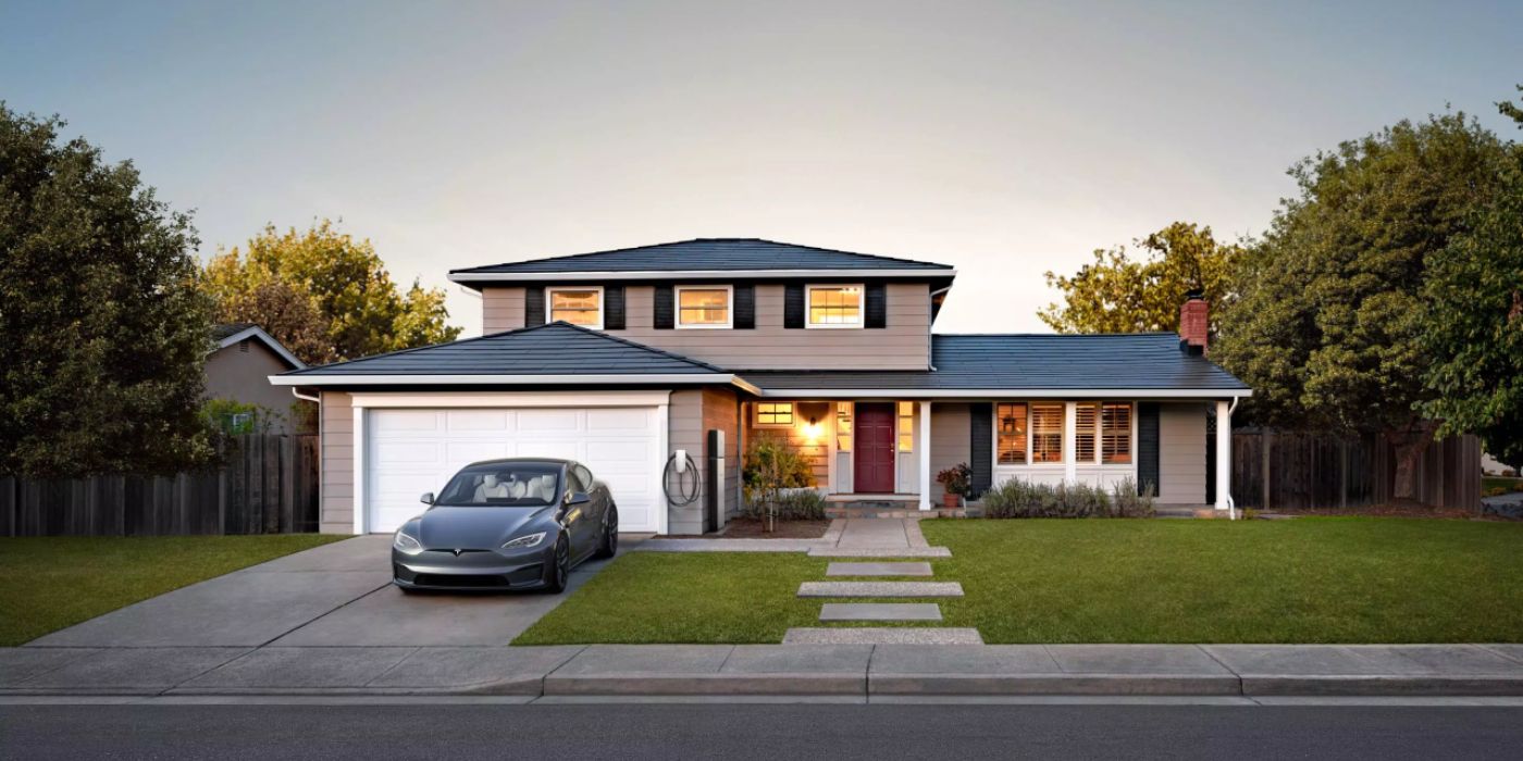 A house using Tesla Solar Roof with an EV parked outside