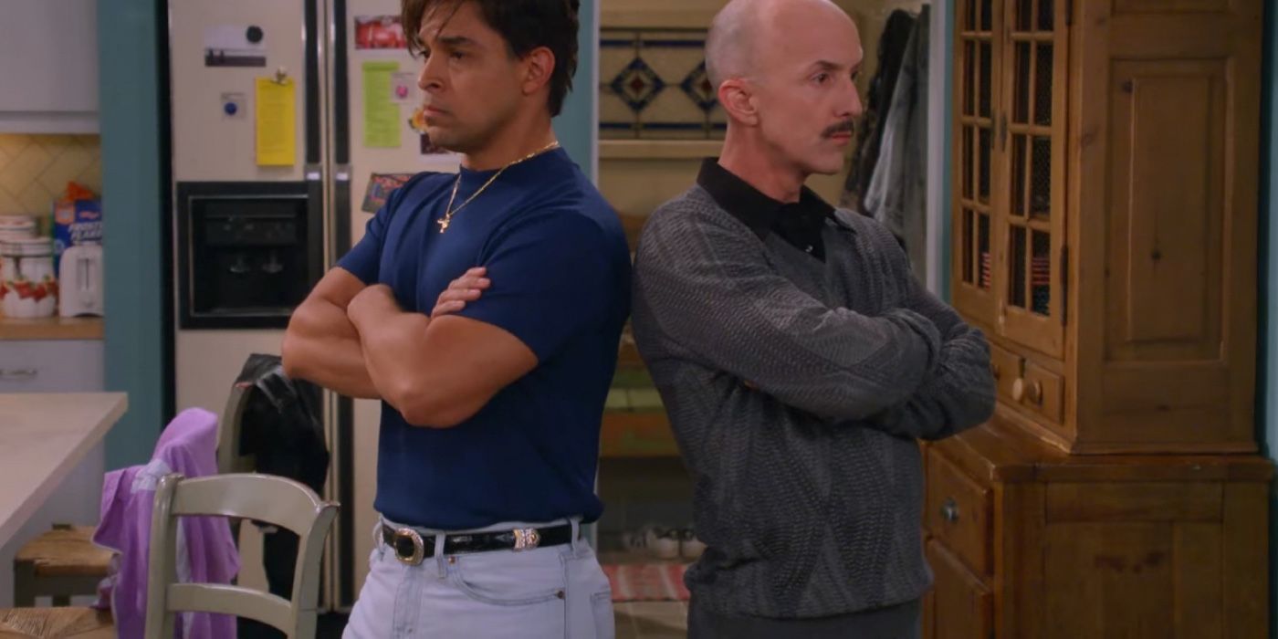 Wilmer Valderrama as Fez crossing his arms and pouting with a repairman doing the same in That '90s Show
