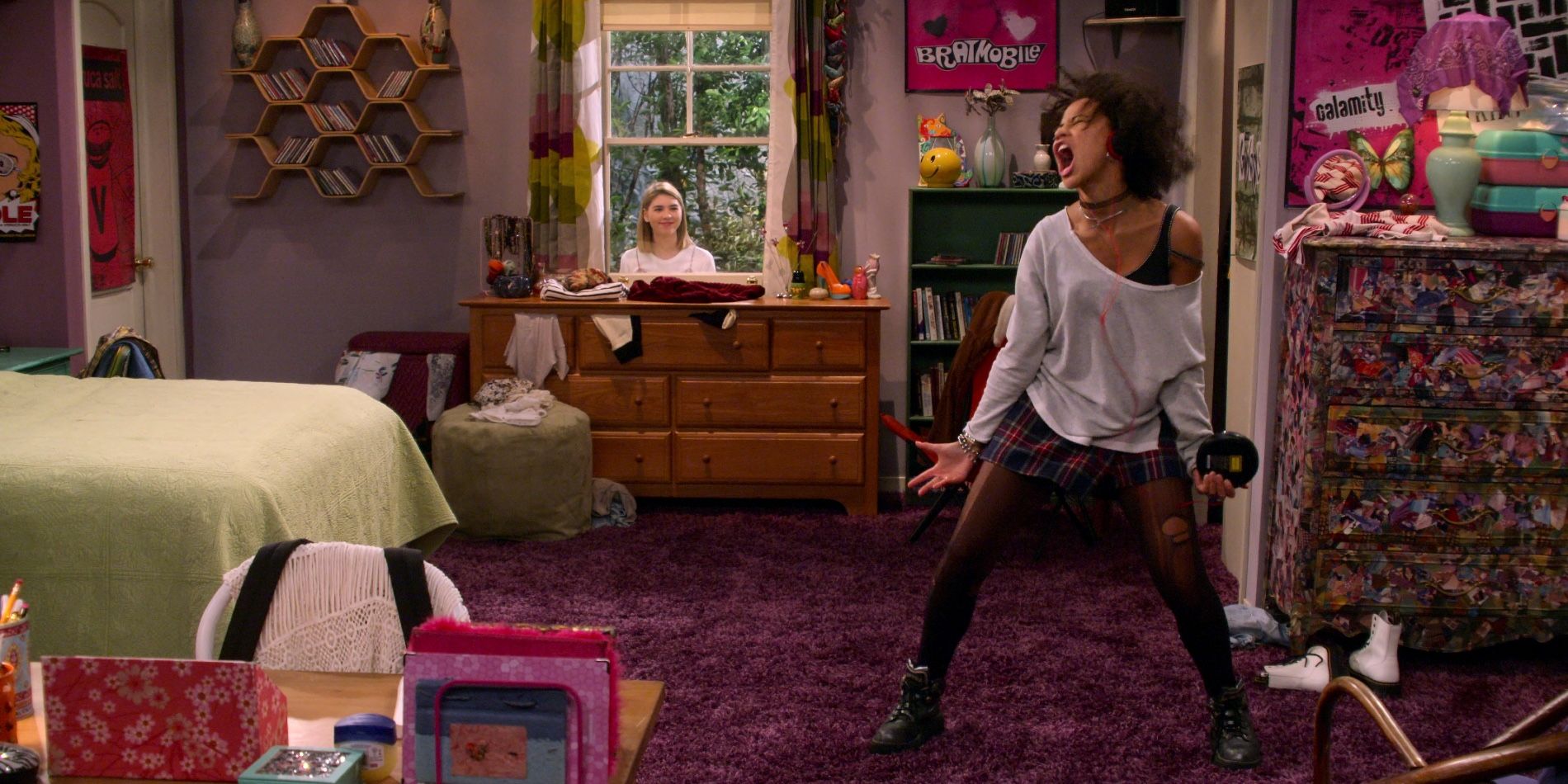 Gwen Runck dancing in Donna's old bedroom while Leia Forman looks in the window in That '90s Show
