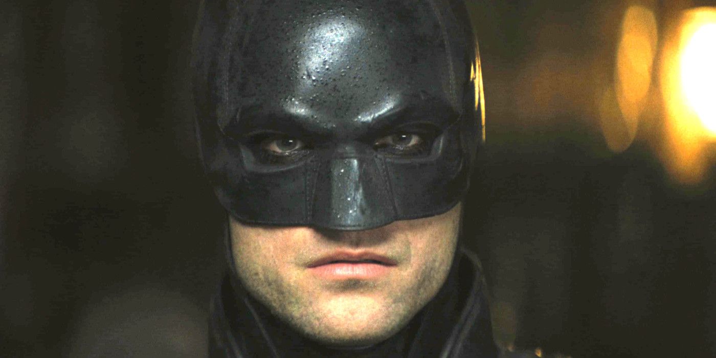 Robert Pattinson em The Batman usando a icônica máscara do Batman e olhando diretamente para a câmera