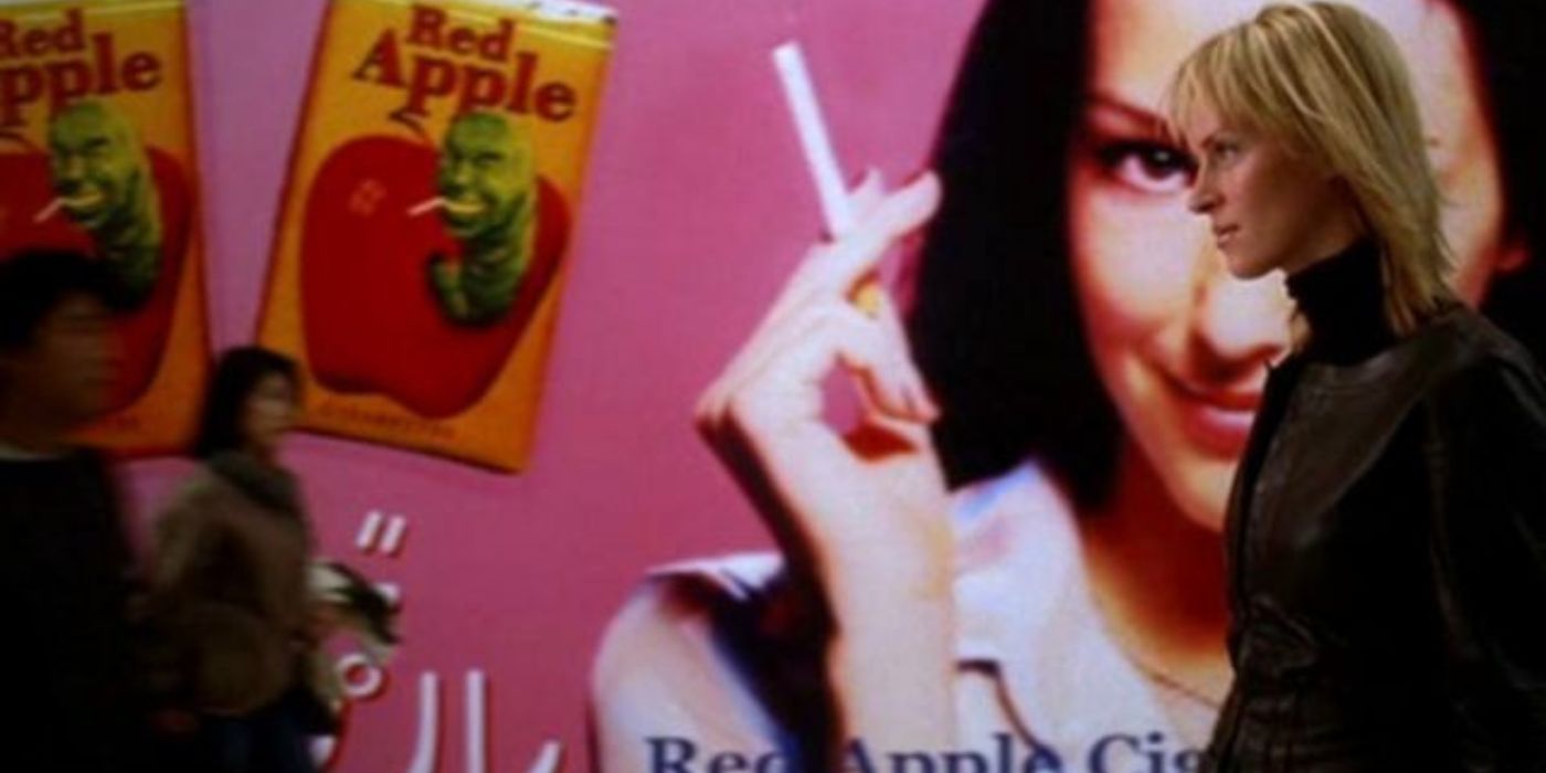 A Noiva passando por um outdoor de um anúncio da Red Apple Cigarettes