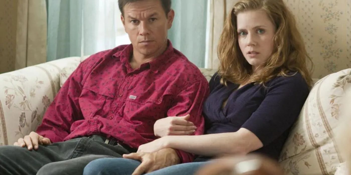 Mark Wahlberg and Amy Adams sitting on a couch in The Fighter