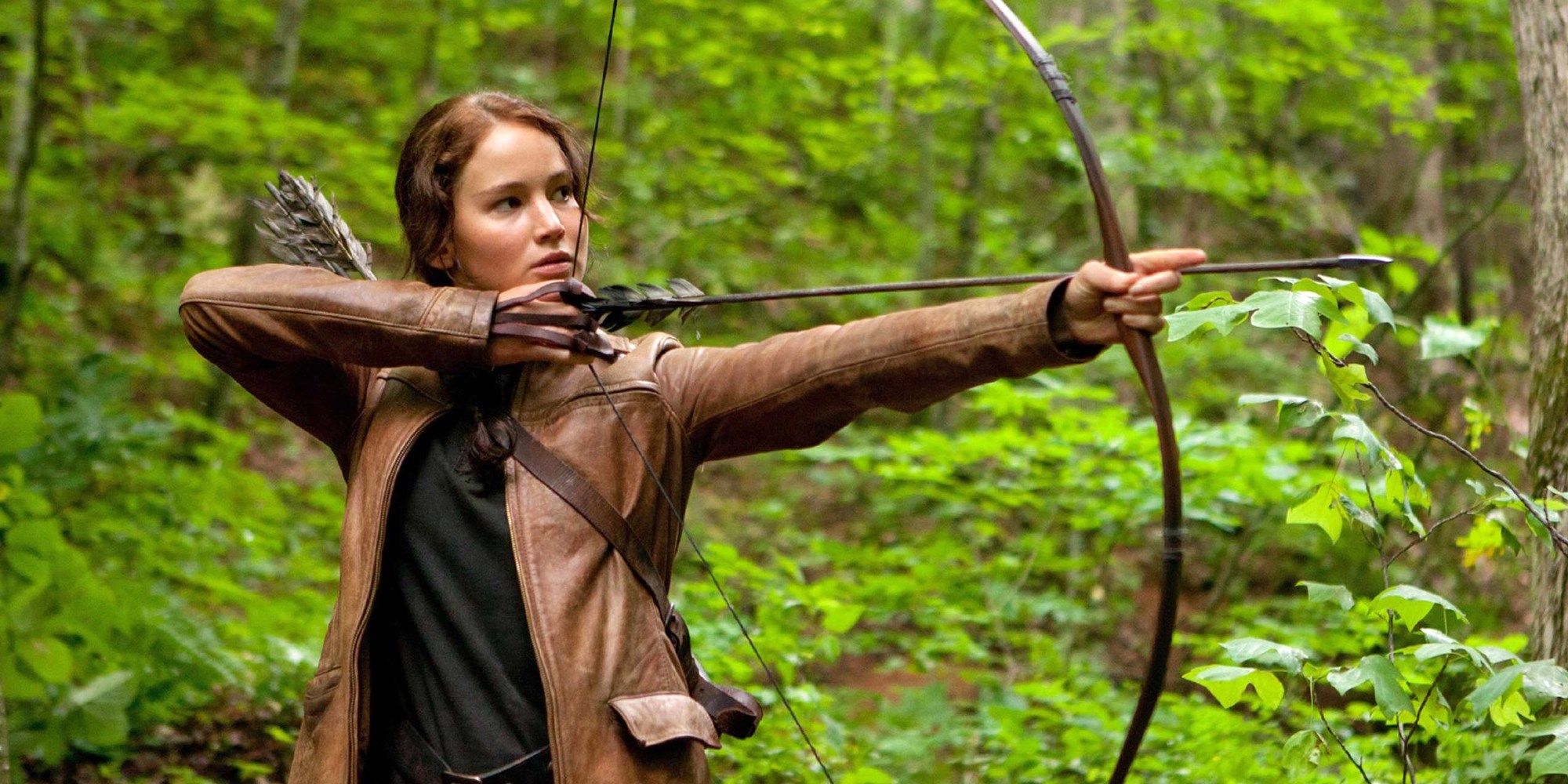 Jennifer Lawrence como Katniss Everdeen atirando uma flecha em Jogos Vorazes