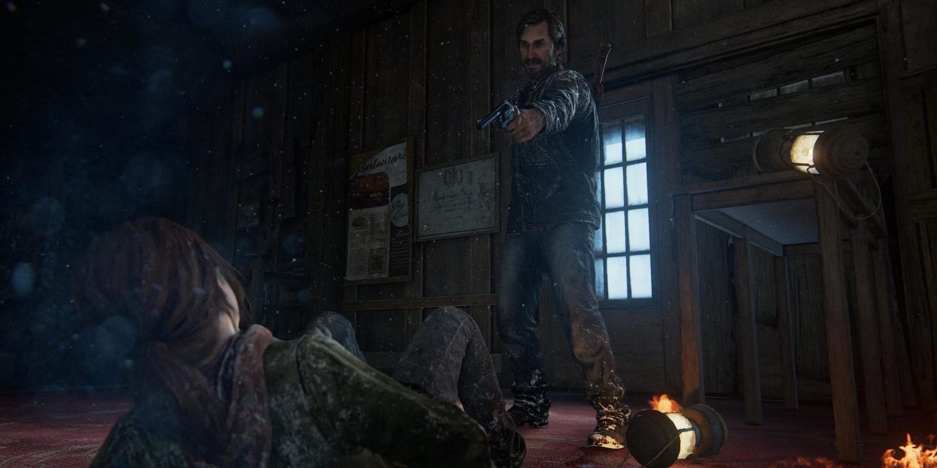 The Last of Us' David stands and points a gun at Ellie, which is on the ground.
