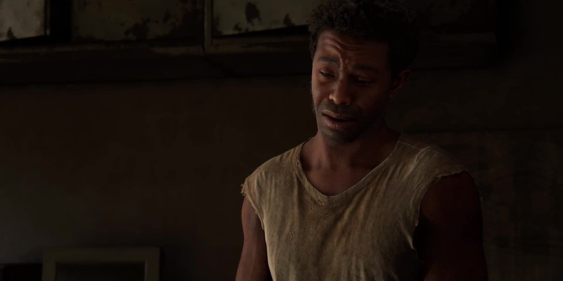 The Last of Us' Henry cries while weaing a dirty white T-shirt with cut-off sleeves.
