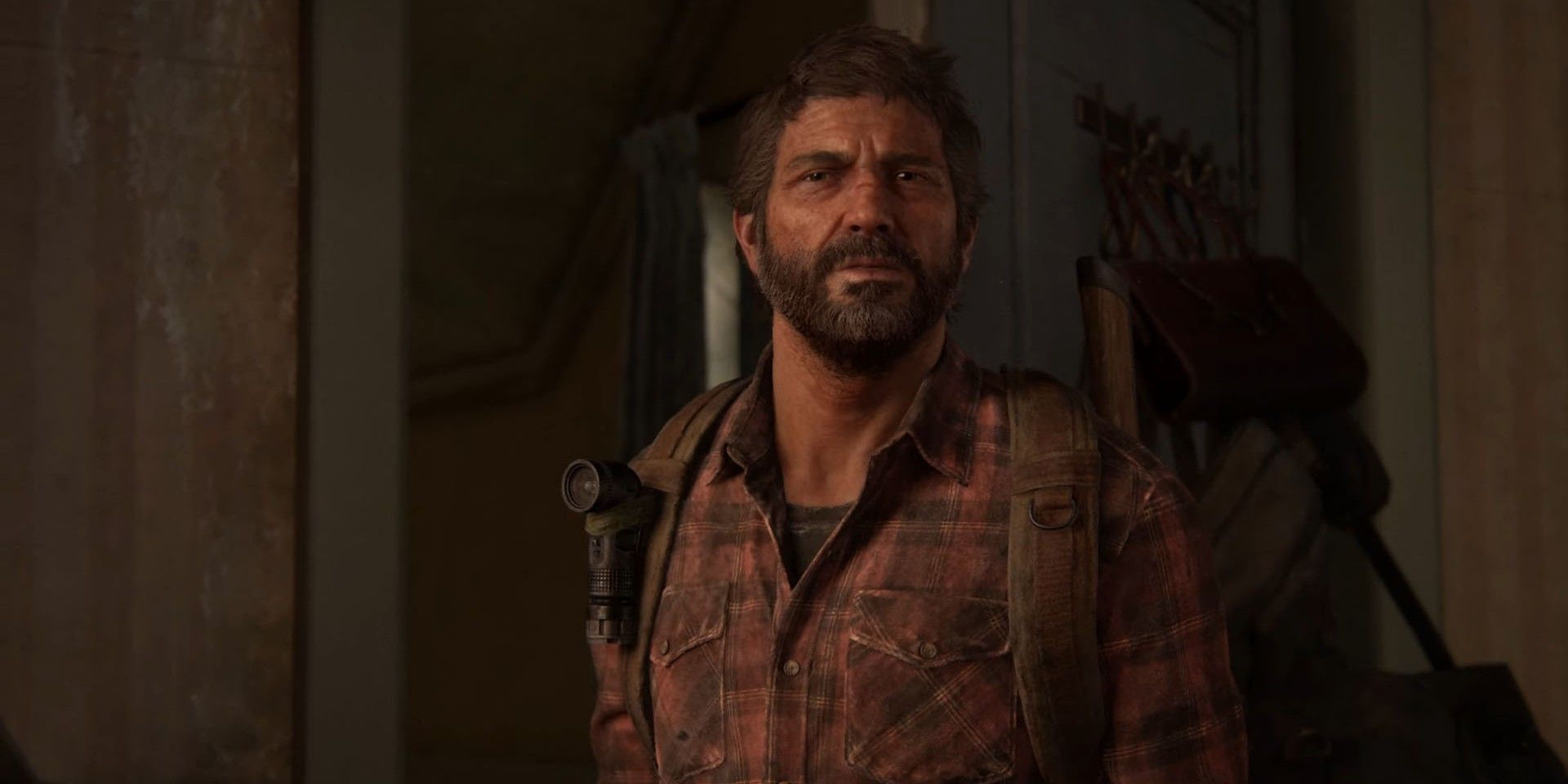 The Last of Us' Joel looks blankly ahead with a door behind him.
