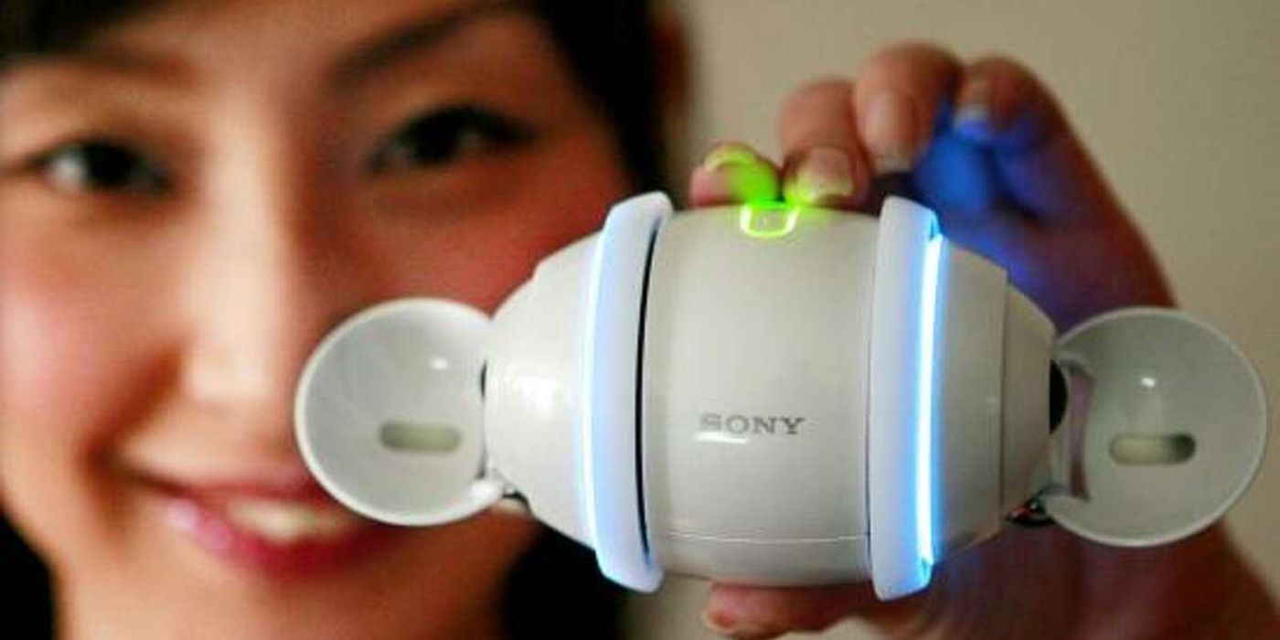 A woman holding up Sony Rolly MP3 speaker