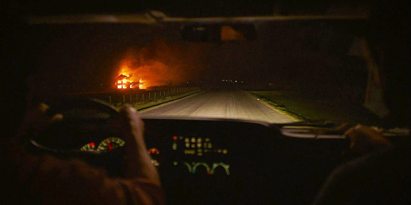 Tommy conduisant la voiture dans leur perspective alors qu'une maison est en feu dans The Last Of Us