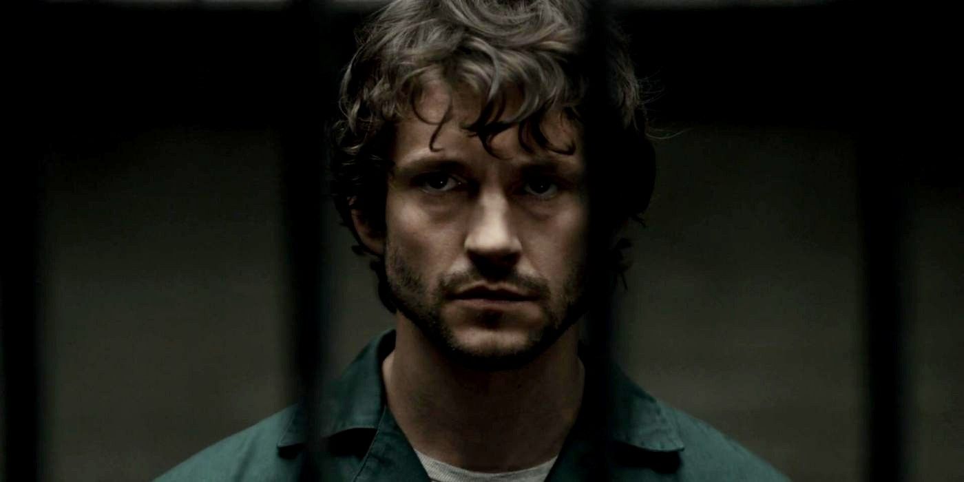 Will with a neutral expression and behind bars in Hannibal