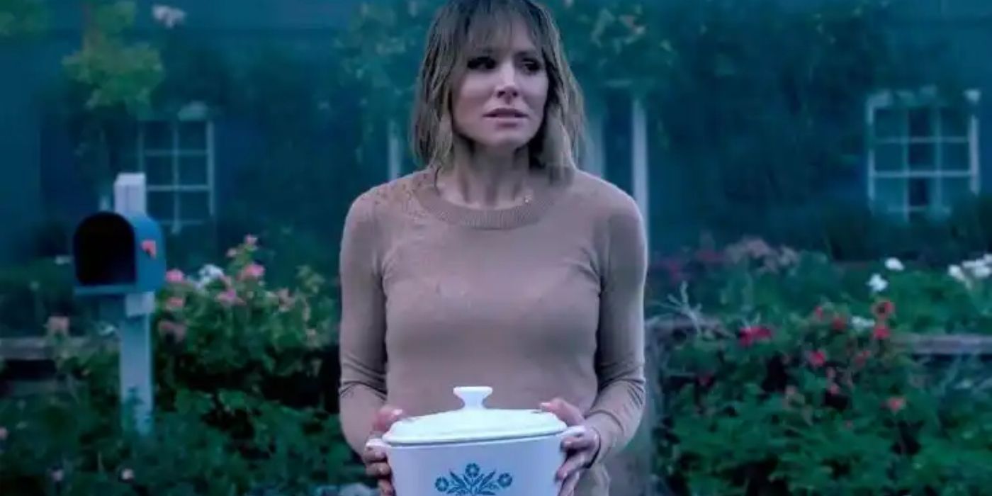 Anna holding a casserole dish in The Woman in the House Across The Street