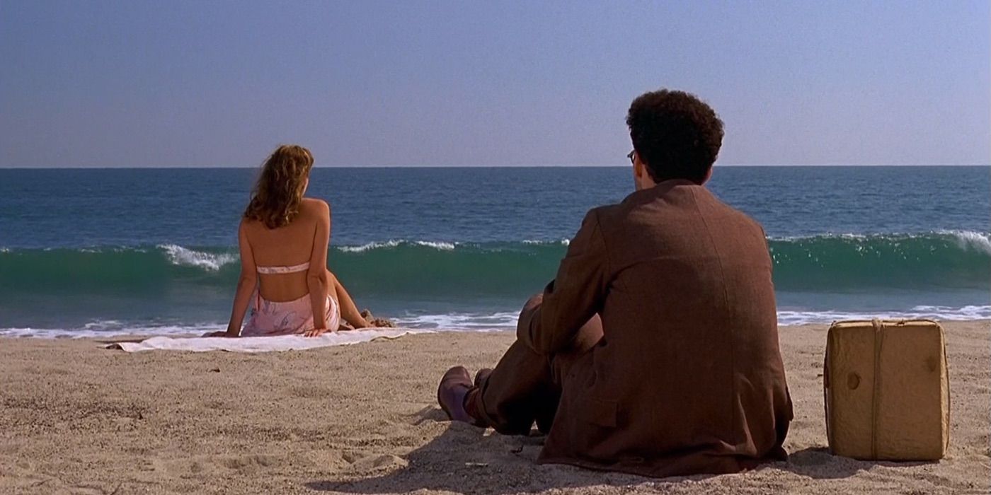 Barton sits behind a woman on the beach in Barton Fink